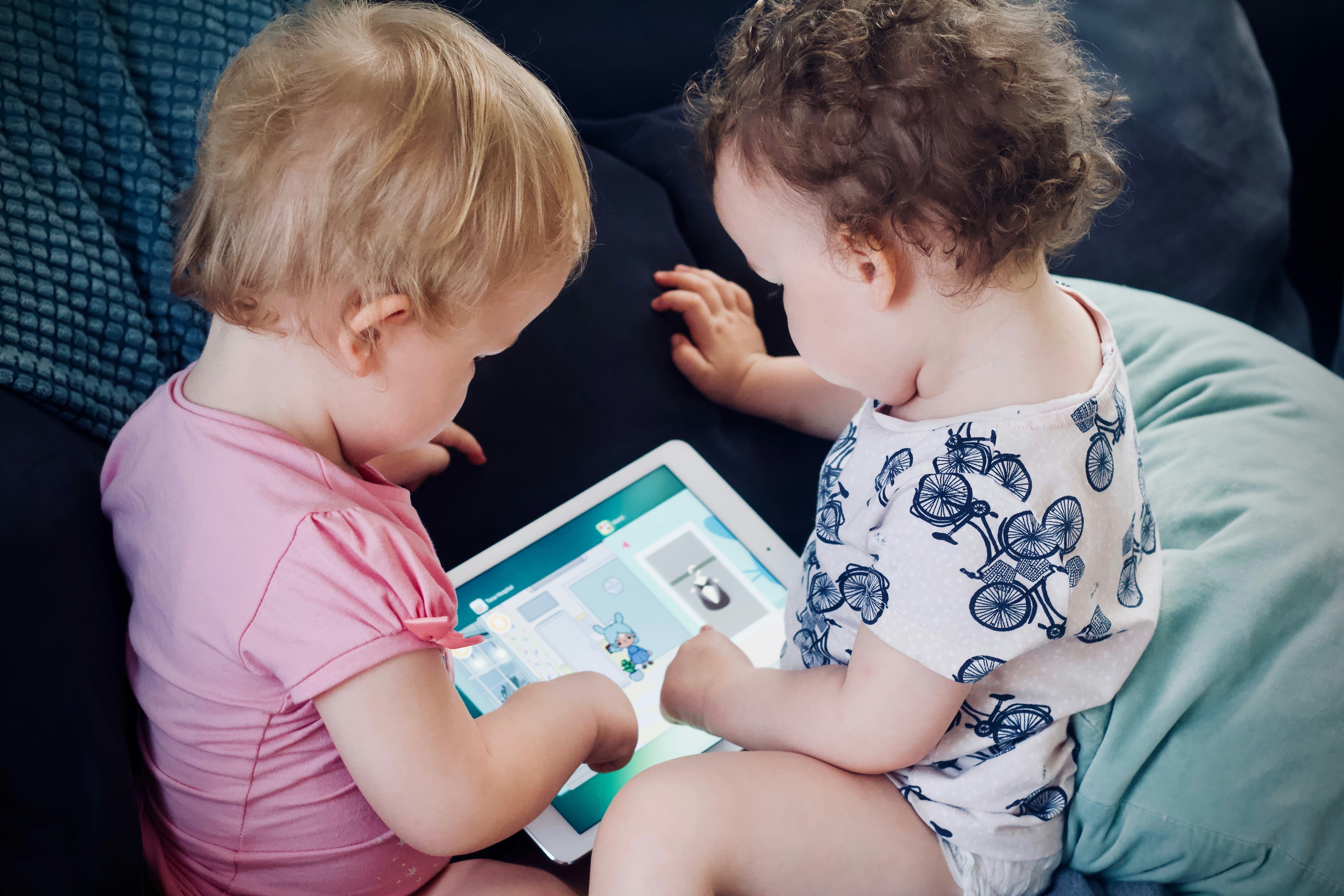 Zwei Kinder beschäftigen sich mit ihrem Tablet | Quelle: Unsplash