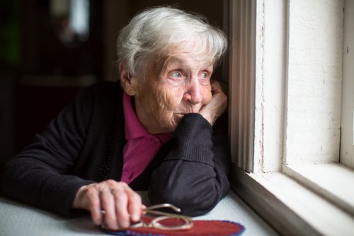 Alte Frau schaut aus dem Fenster | Quelle: Shutterstock