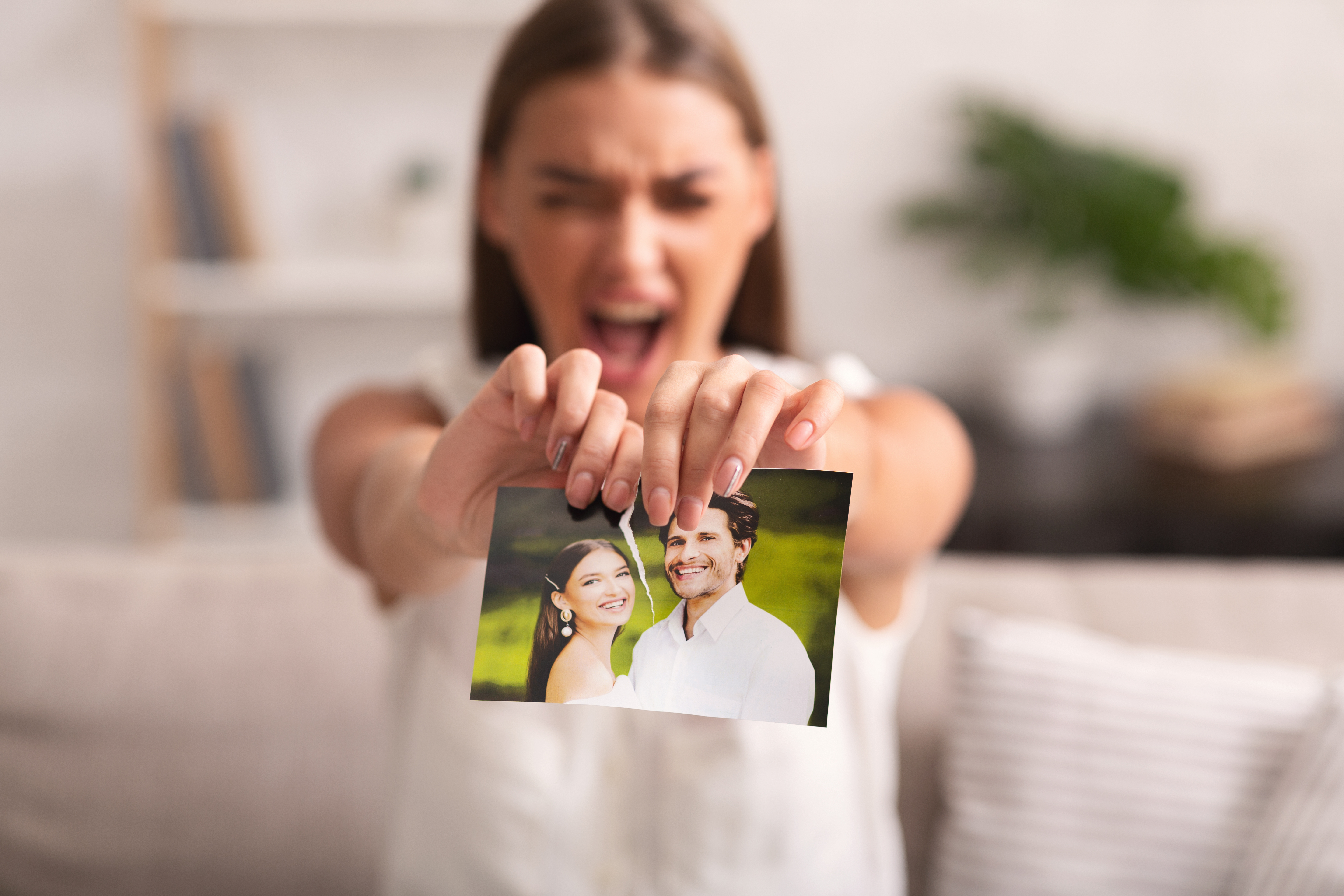 Eine Frau zerreißt ein Foto von sich und einem Mann | Quelle: Shutterstock