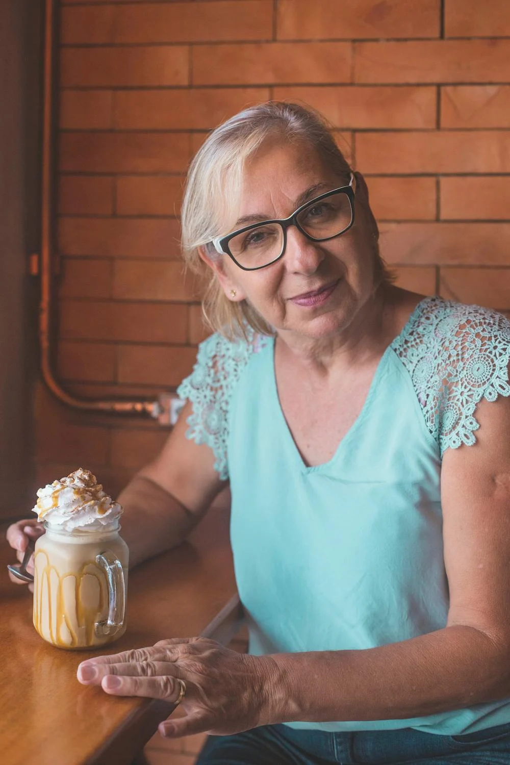 Eine lächelnde Frau beim Kaffeetrinken ⏐ Quelle: Pexels