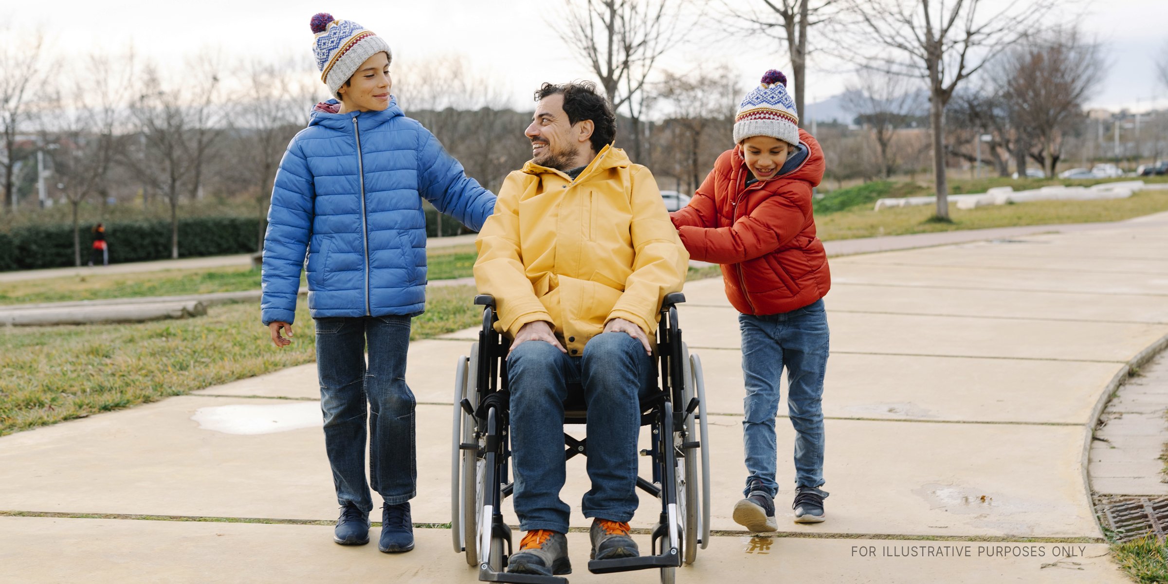 Zwei Kinder unterhalten sich mit einem Mann im Rollstuhl. | Quelle: Getty Images