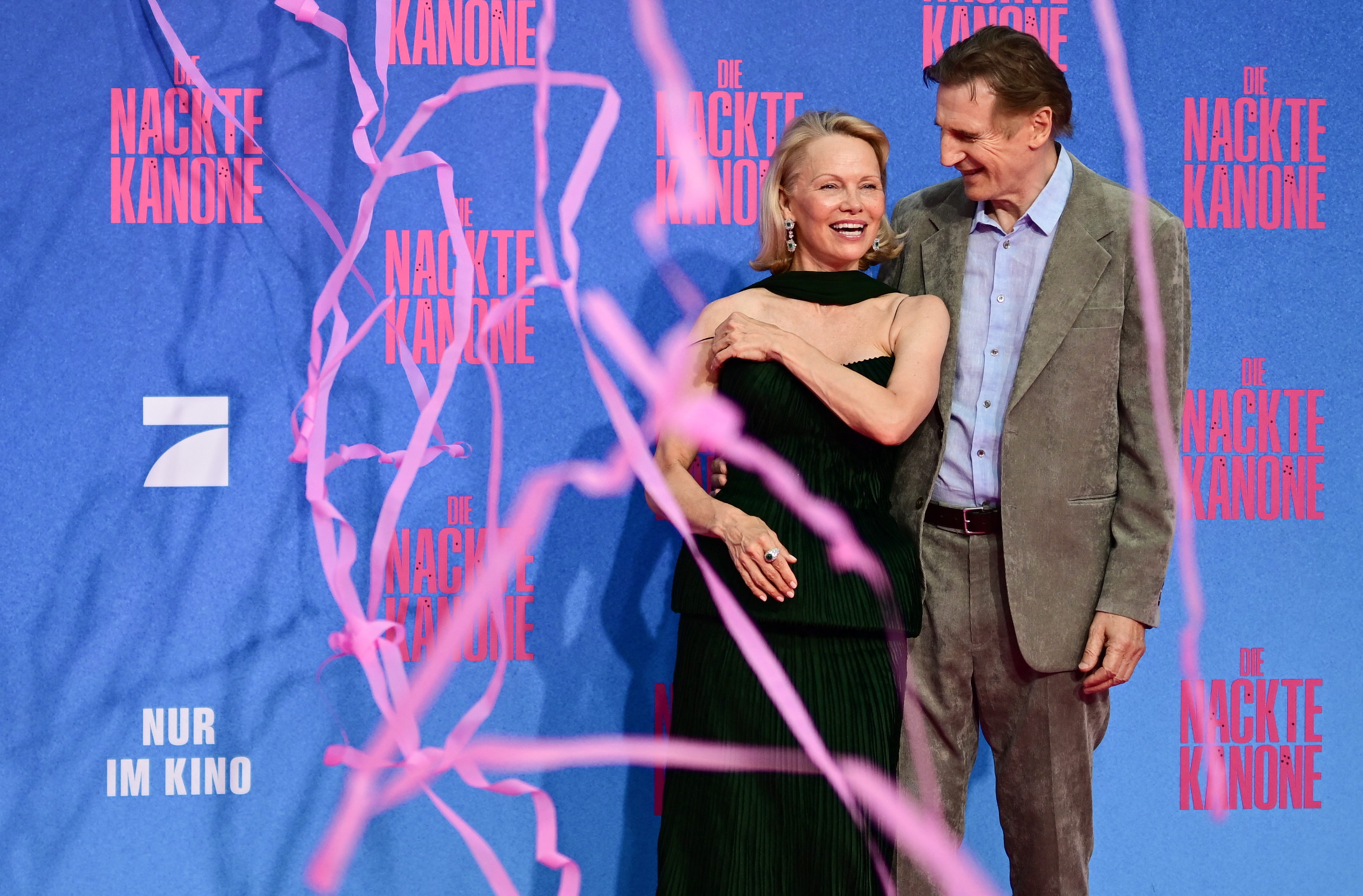 Liam Neeson und Pamela Anderson posieren bei ihrer Ankunft zur deutschen Premiere von „Die nackte Kanone“ in Berlin am 24. Juli 2025 auf dem roten Teppich. | Quelle: Getty Images