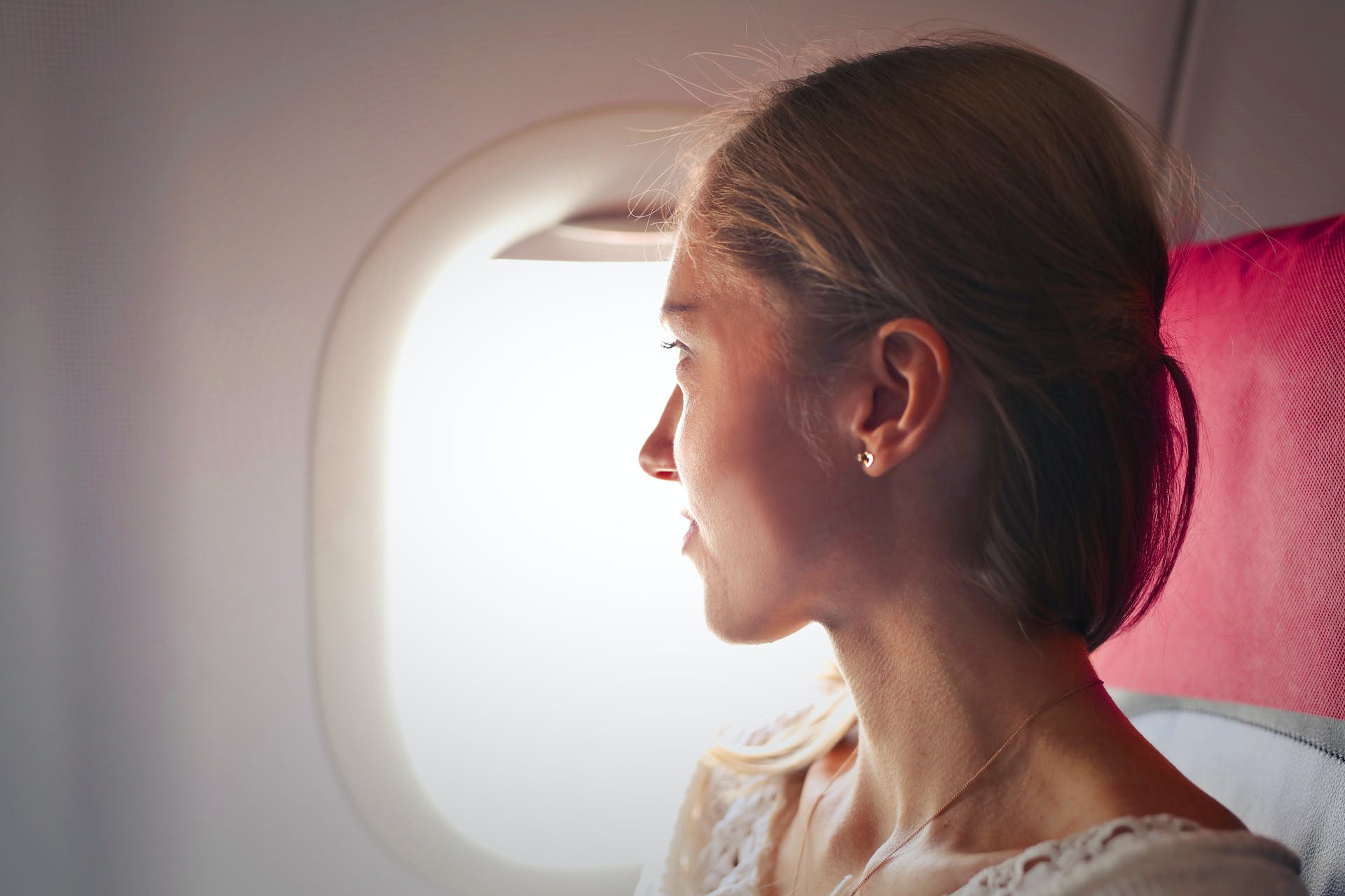 Eine Frau, die aus dem Fenster eines Flugzeugs schaut | Quelle: Pexels