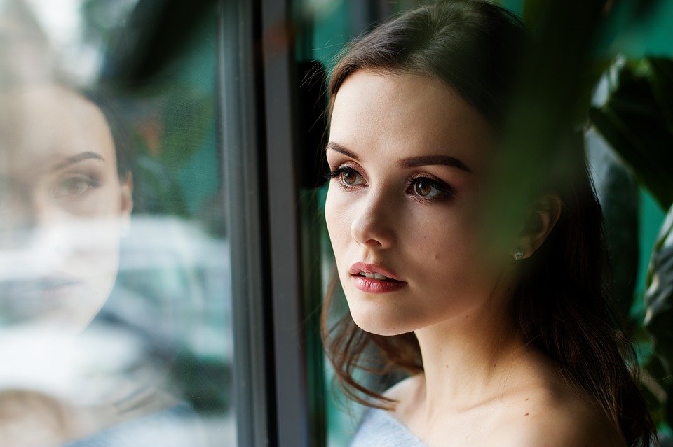 Eine Frau steht am Fenster. | Quelle: pixabay.com