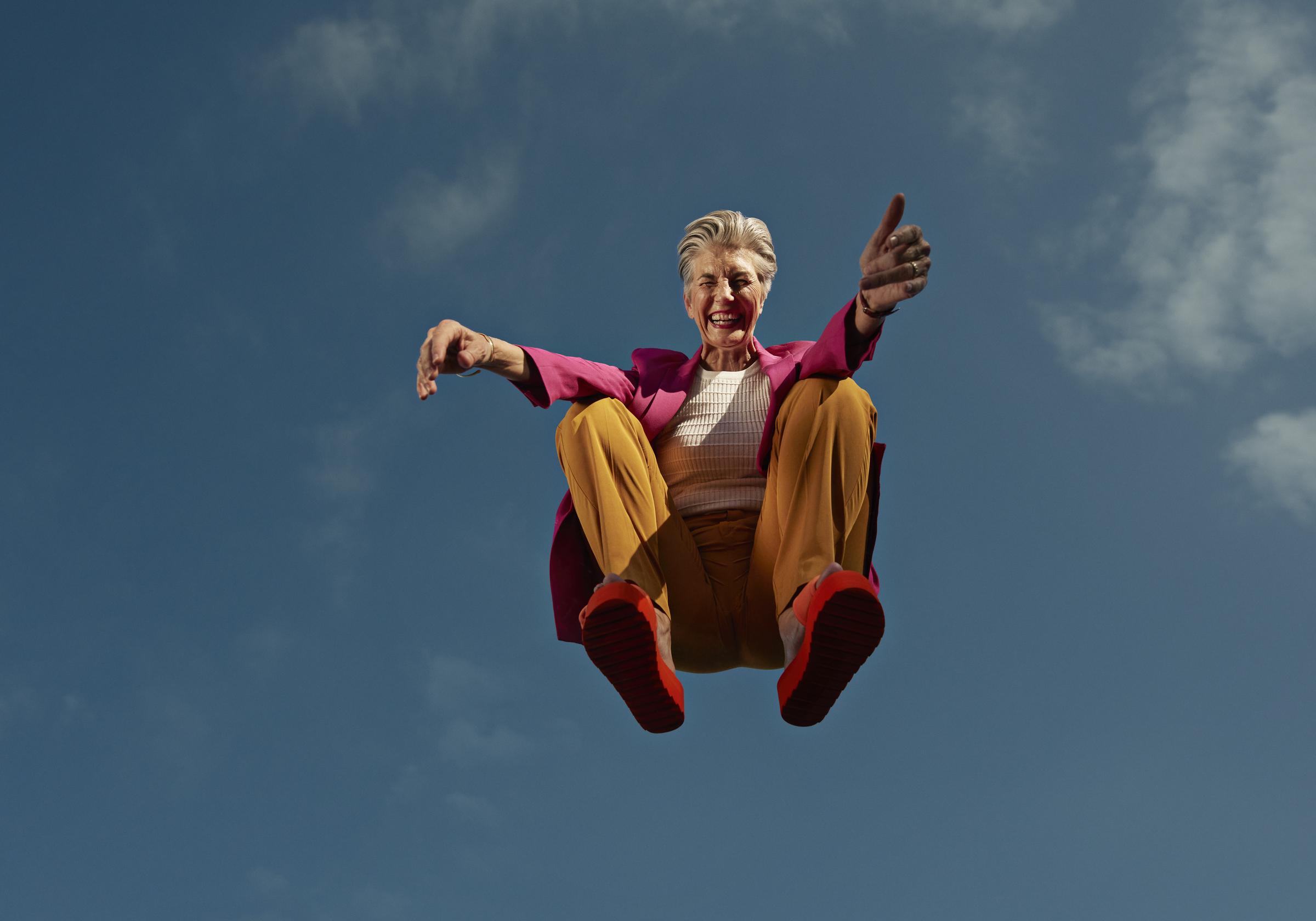 Eine Frau hockt in der Luft vor dem blauen Himmel | Quelle: Getty Images