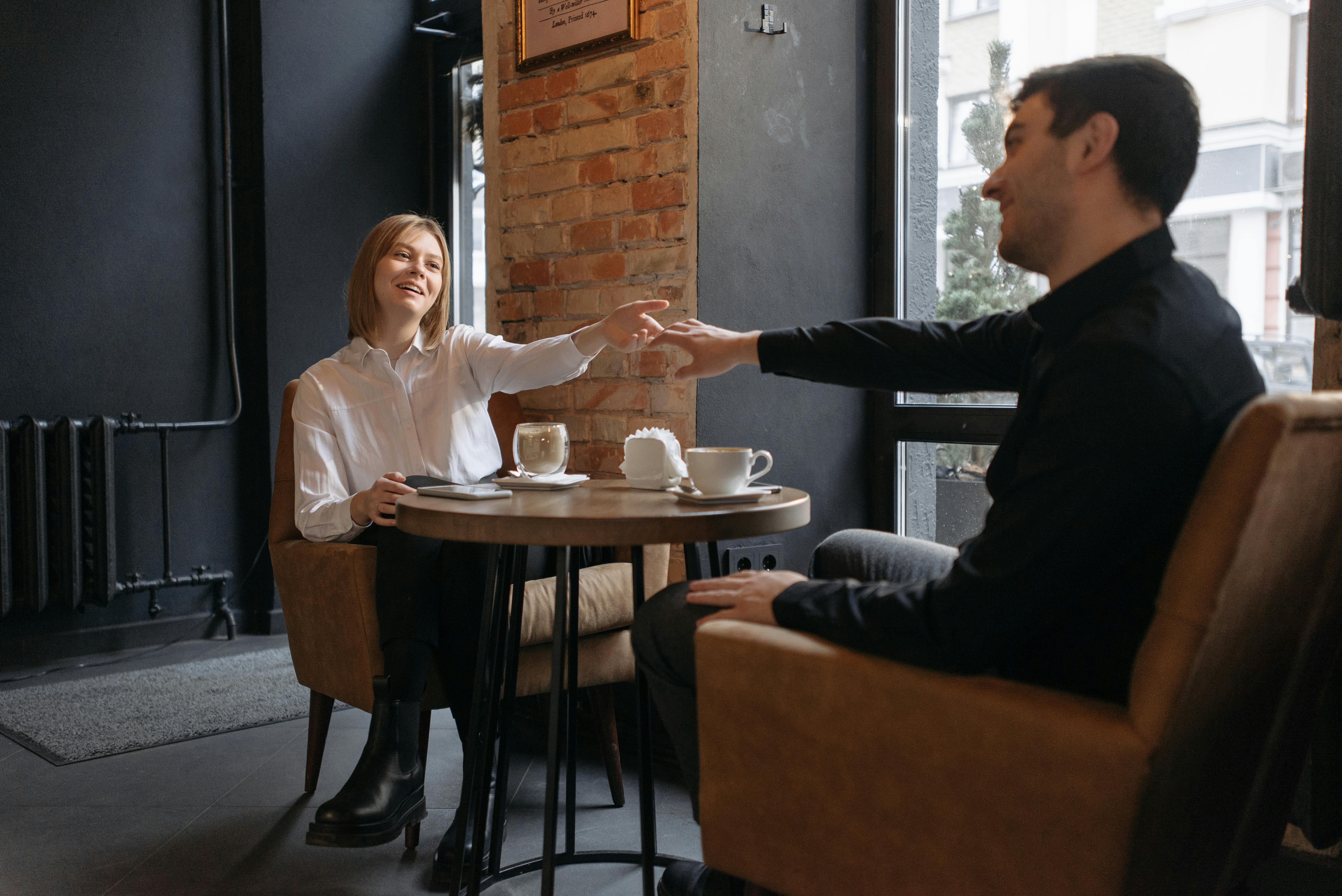 Ein Mann und eine Frau unterhalten sich in einem Cafe | Quelle: Pexels