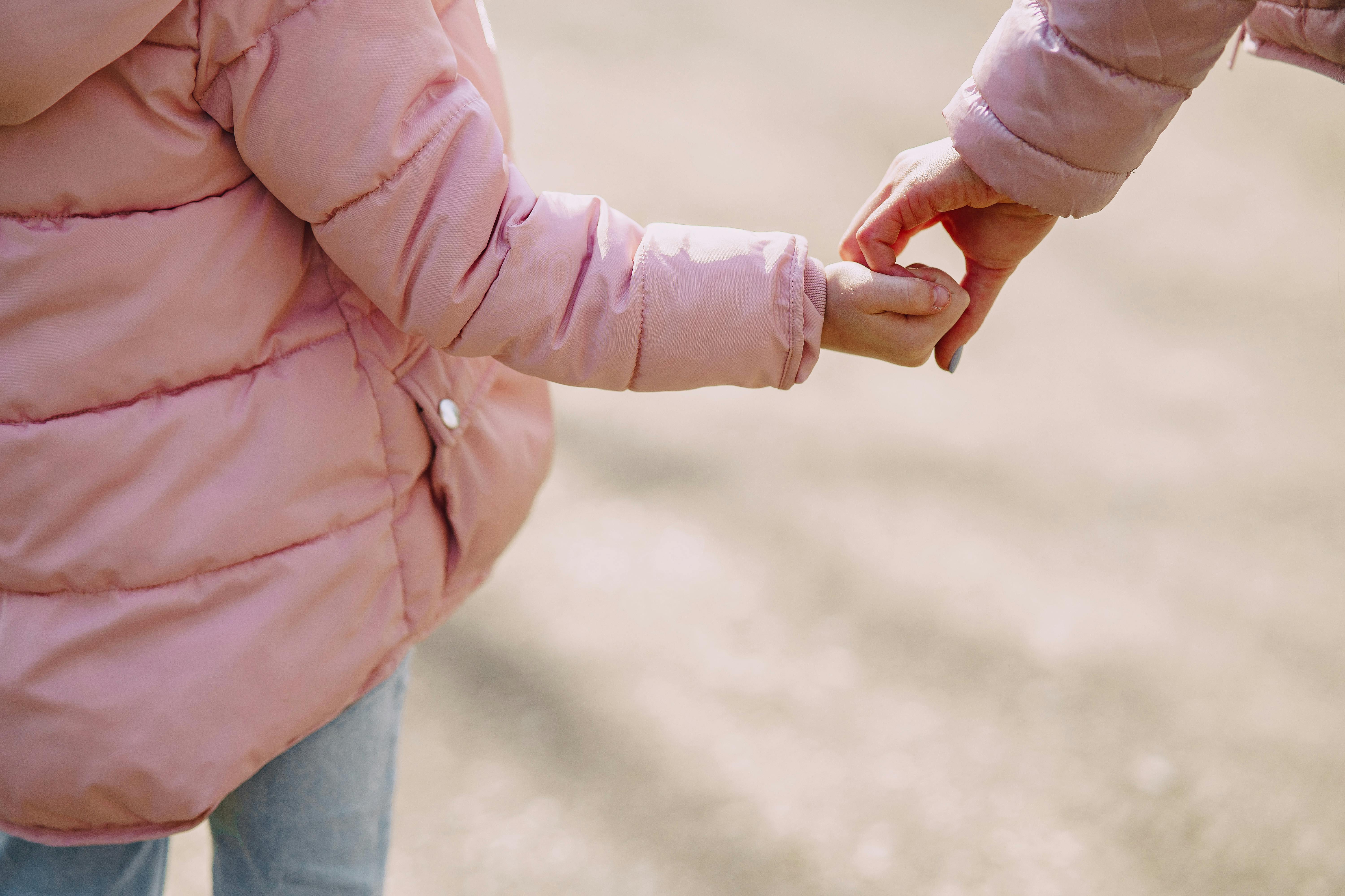 Eine Mutter hält die Hand ihrer kleinen Tochter | Quelle: Pexels