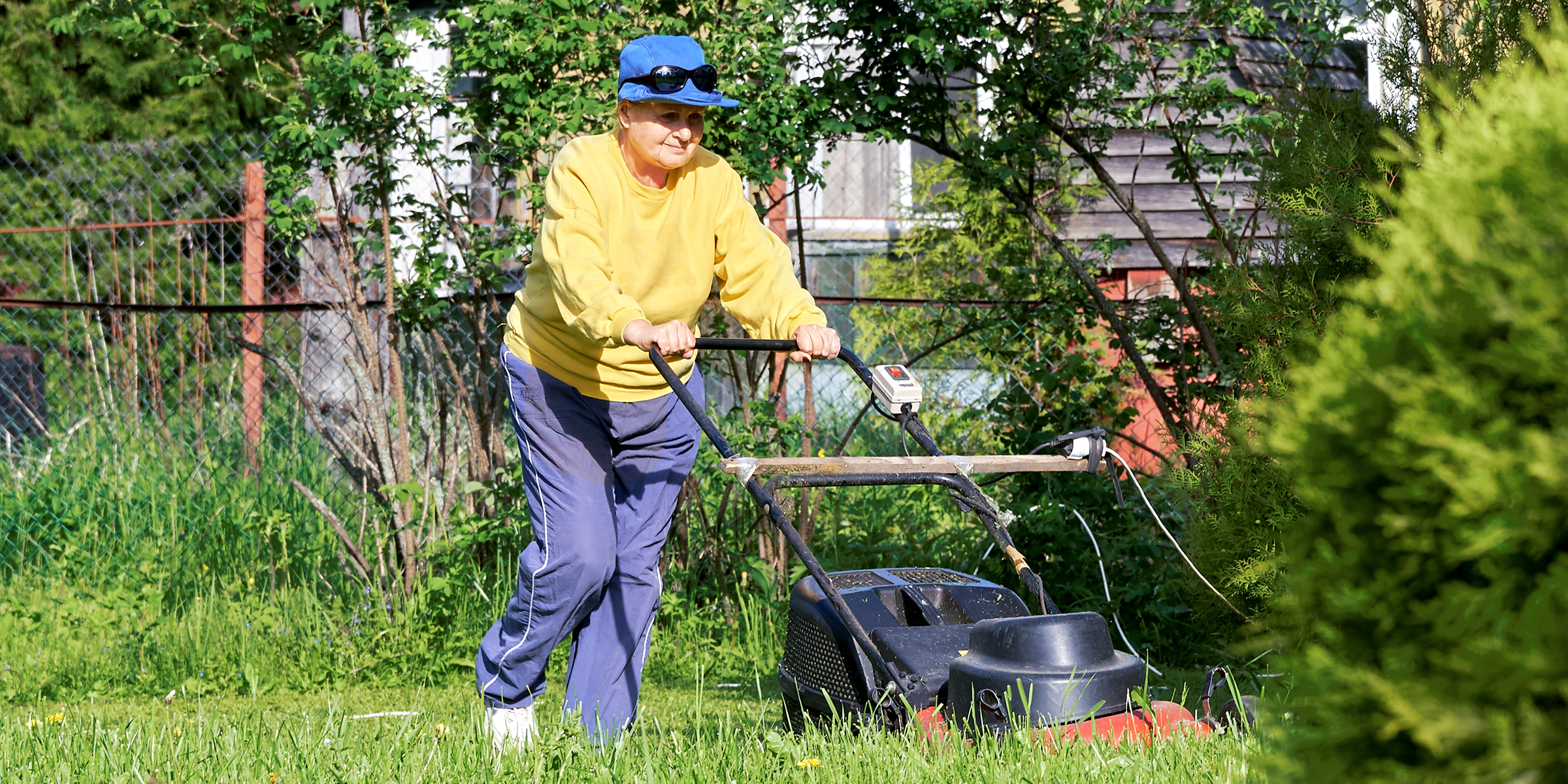 Eine Frau mäht ihren Rasen | Quelle: Shutterstock