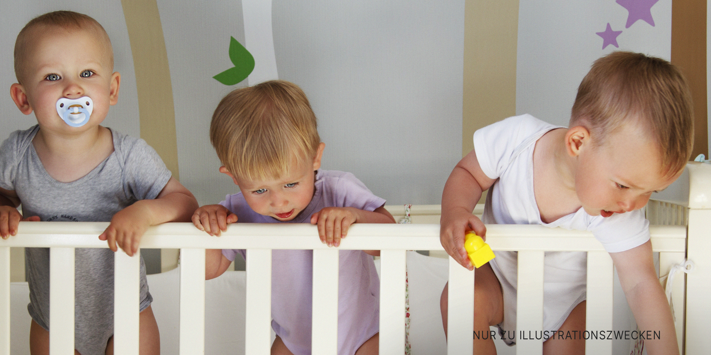 Drei Babys in einem Kinderbett | Quelle: Shutterstock