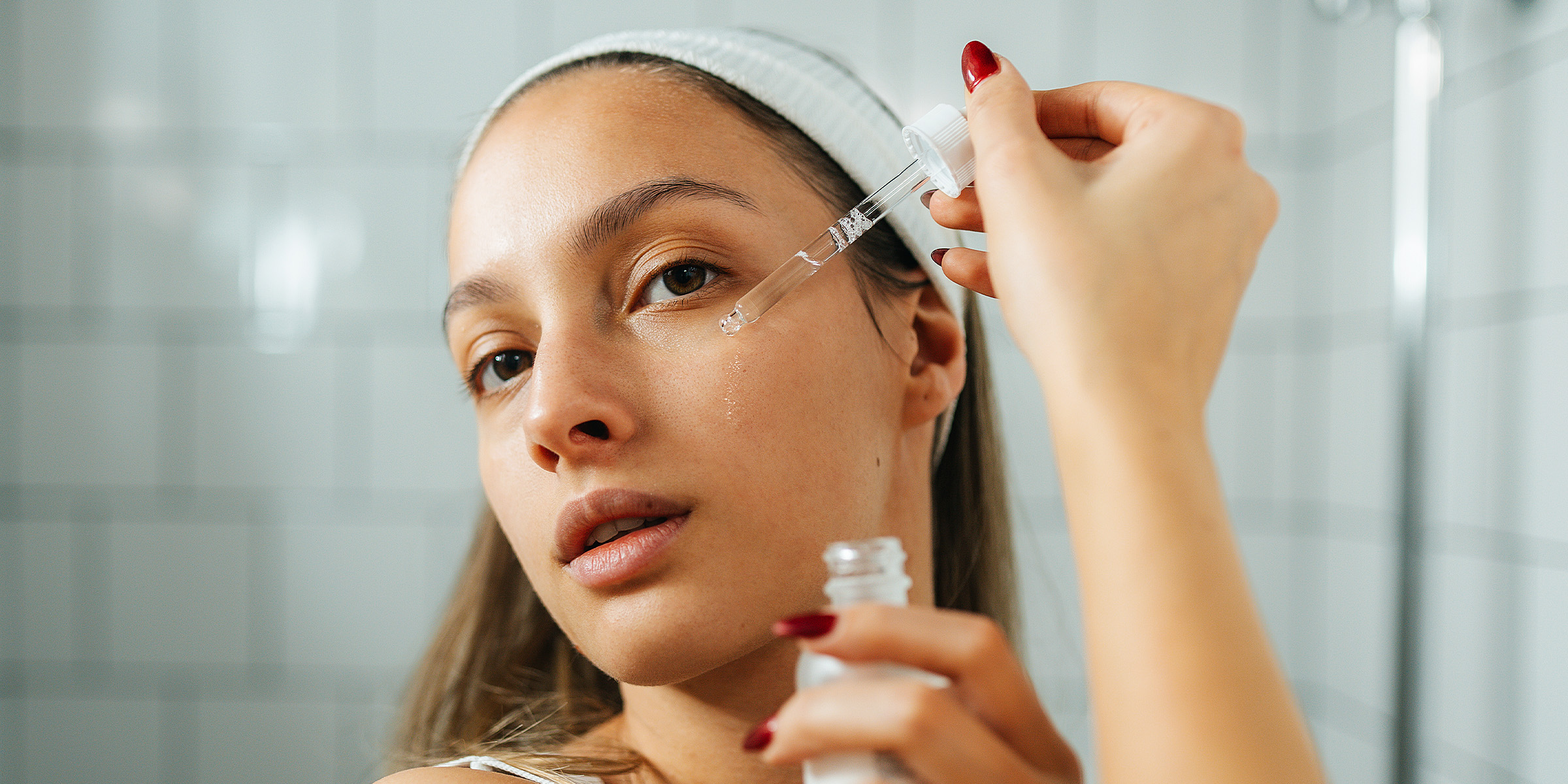 Eine Frau trägt ein Serum auf ihr Gesicht auf | Quelle: Getty Images