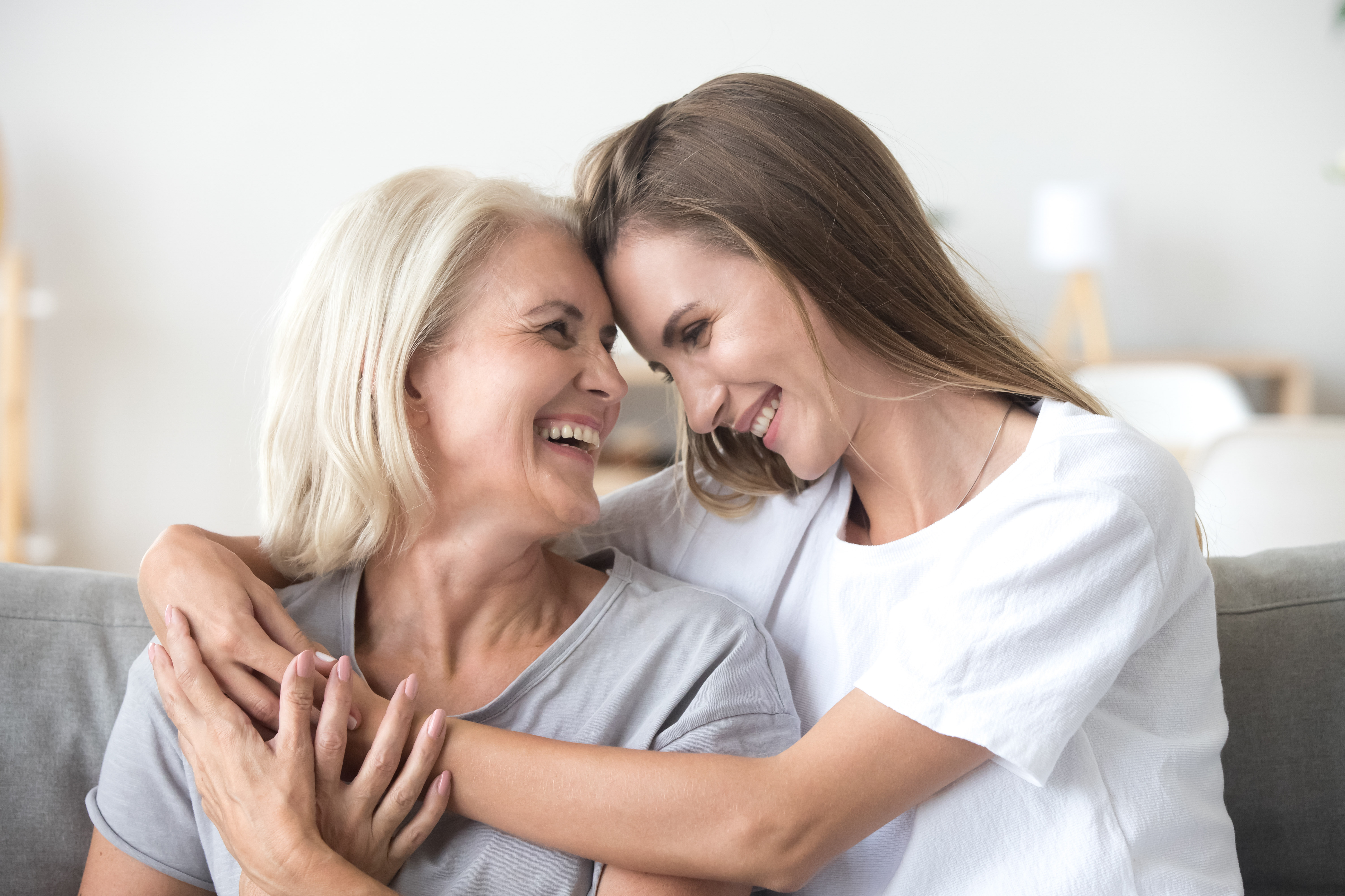 Eine Mutter und ihre Tochter umarmen sich und lächeln sich an | Quelle: Shutterstock