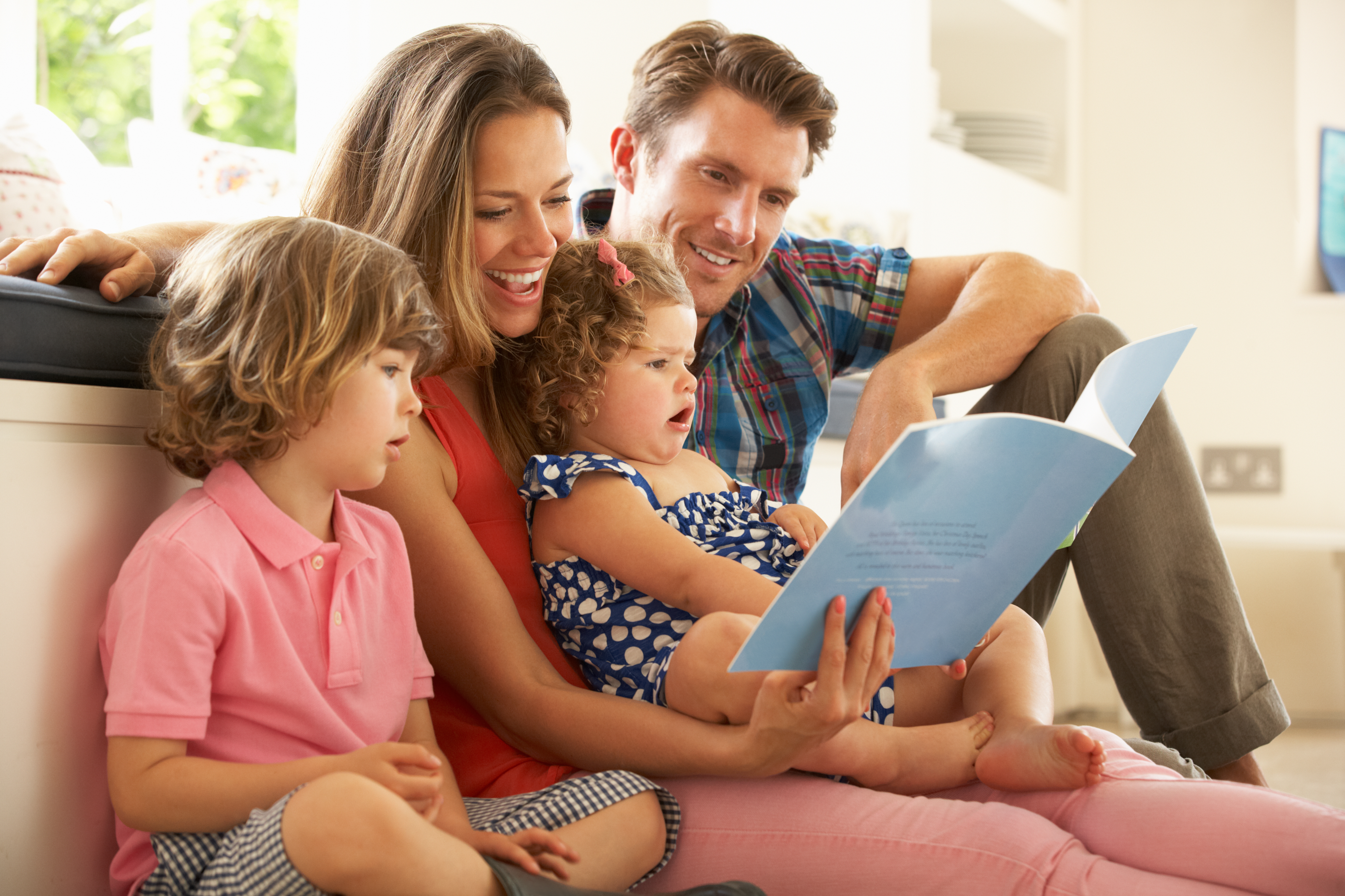 Eine Familie, die gemeinsam ein Buch liest | Quelle: Shutterstock