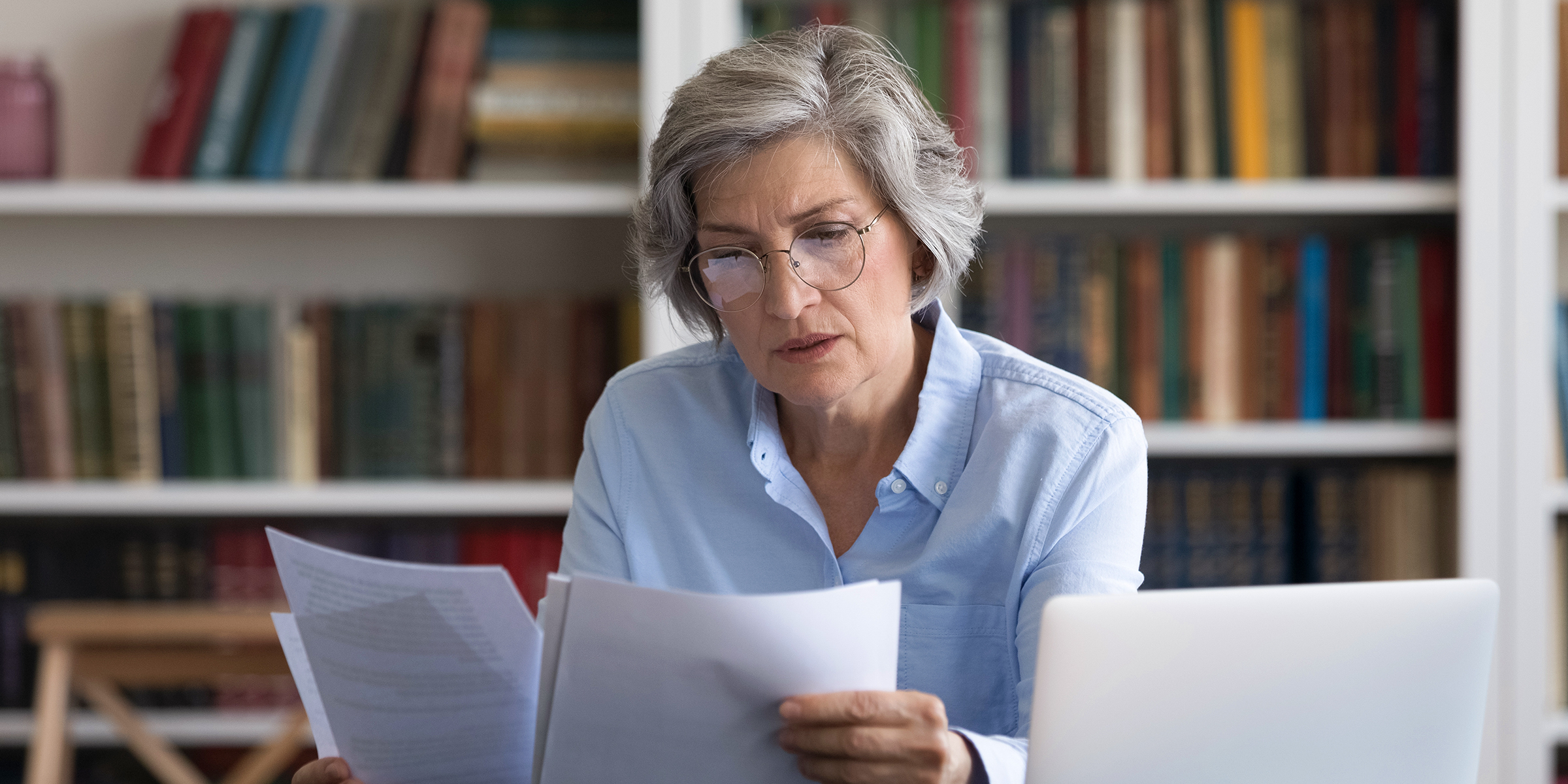Eine ältere Dame beim Lesen von Dokumenten | Quelle: Shutterstock