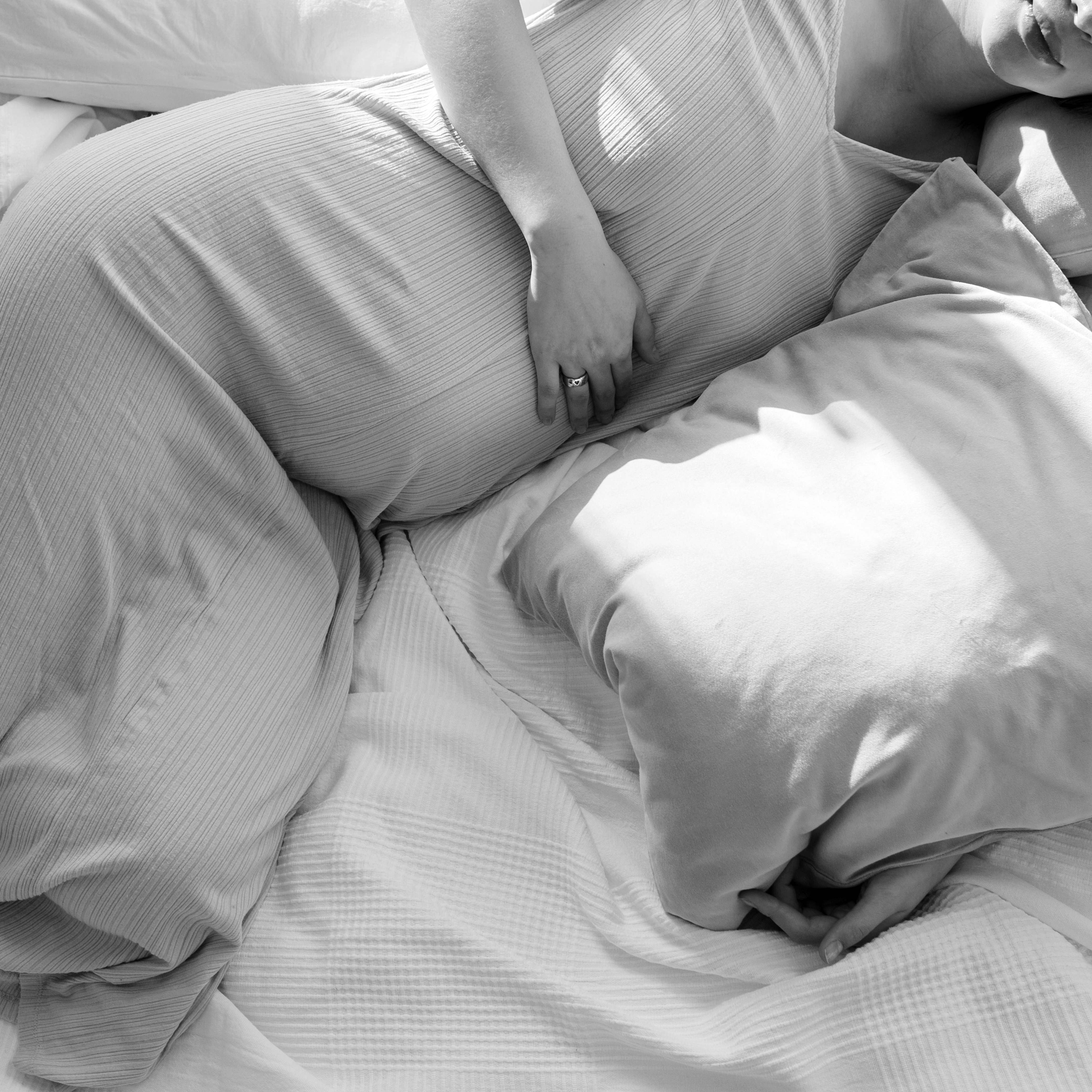 Eine schwangere Frau, die sich im Bett zurücklehnt | Quelle: Pexels