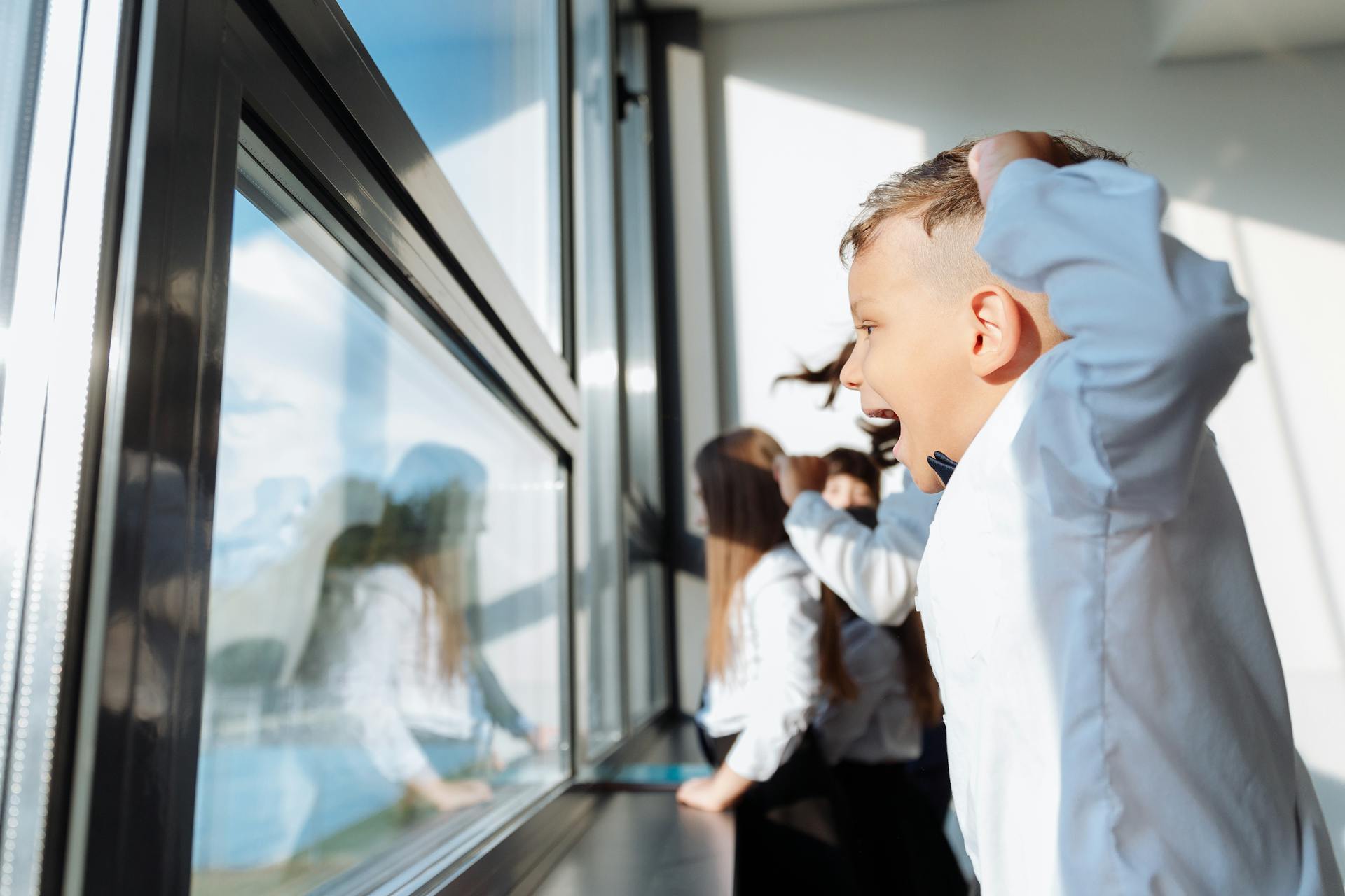 Ein Junge, der aus einem Fenster schaut | Quelle: Pexels