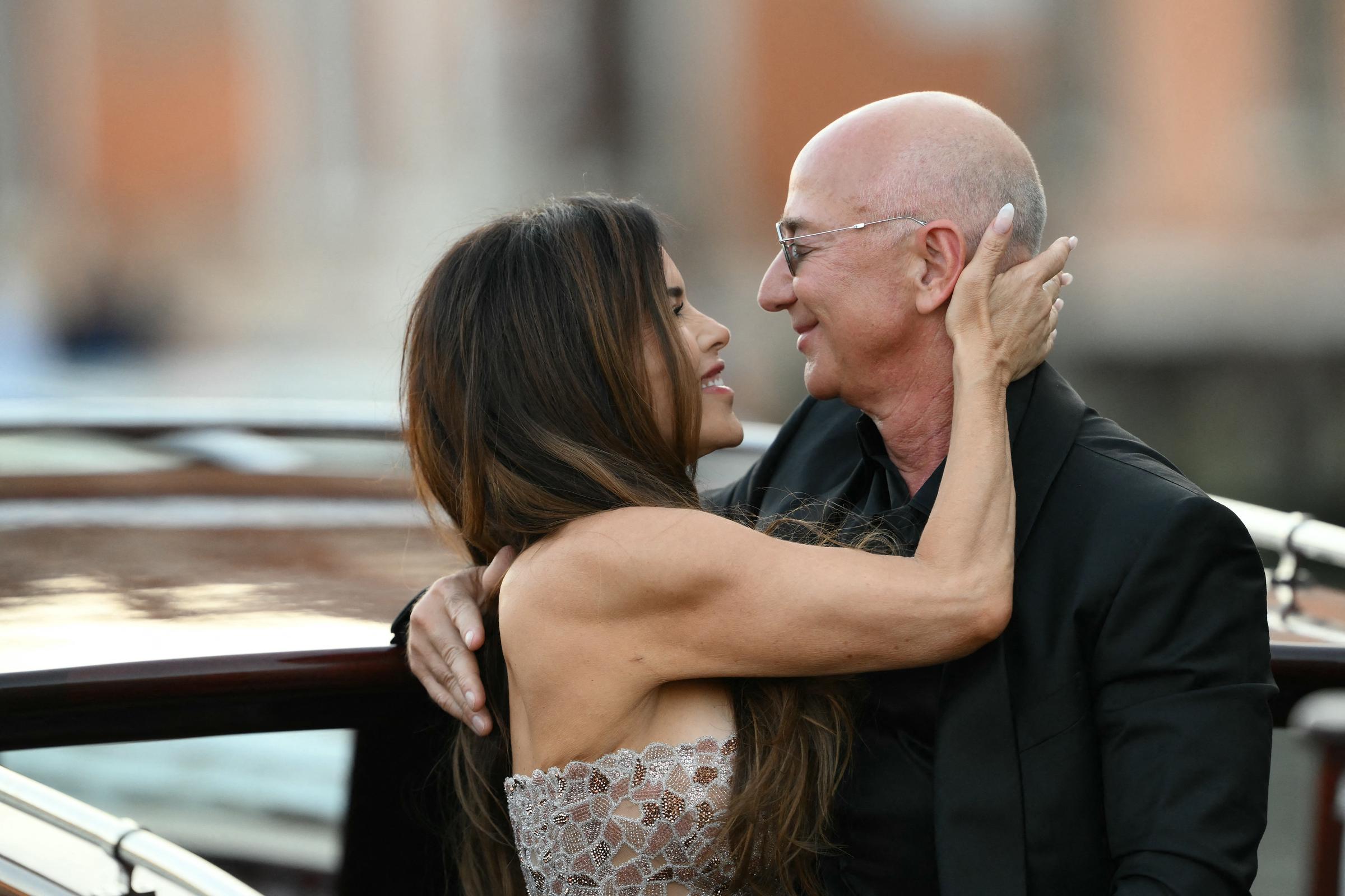 Lauren Sánchez schaut Jeff Bezos liebevoll an, ihre Hand ruht sanft auf seinem Kopf, während sie einen intimen Moment an Bord des Bootes teilen, ihre Gesichter nah beieinander und ihr Lächeln sanft.