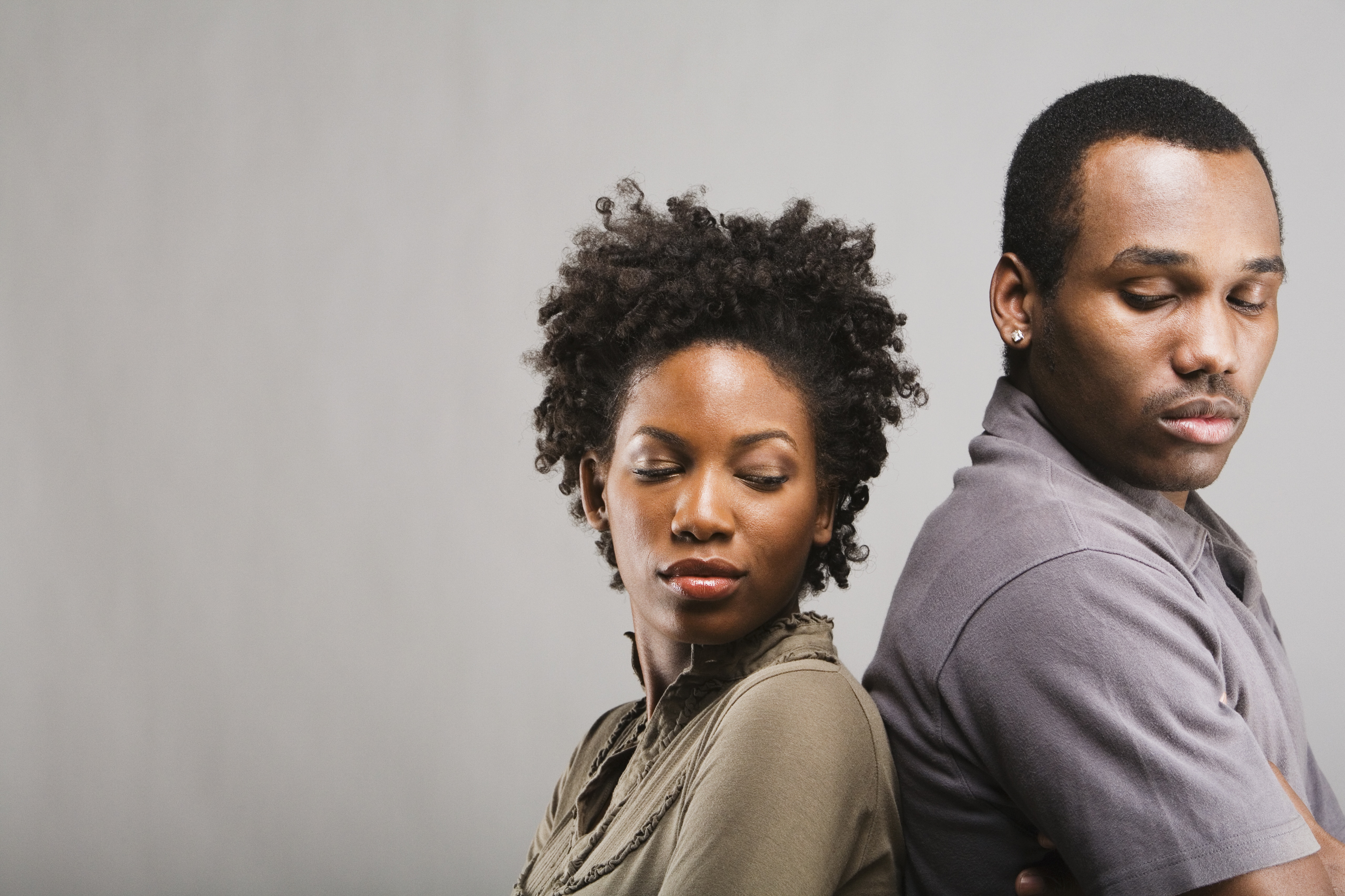 Ein wütendes afroamerikanisches Paar steht Rücken an Rücken | Quelle: Getty Images