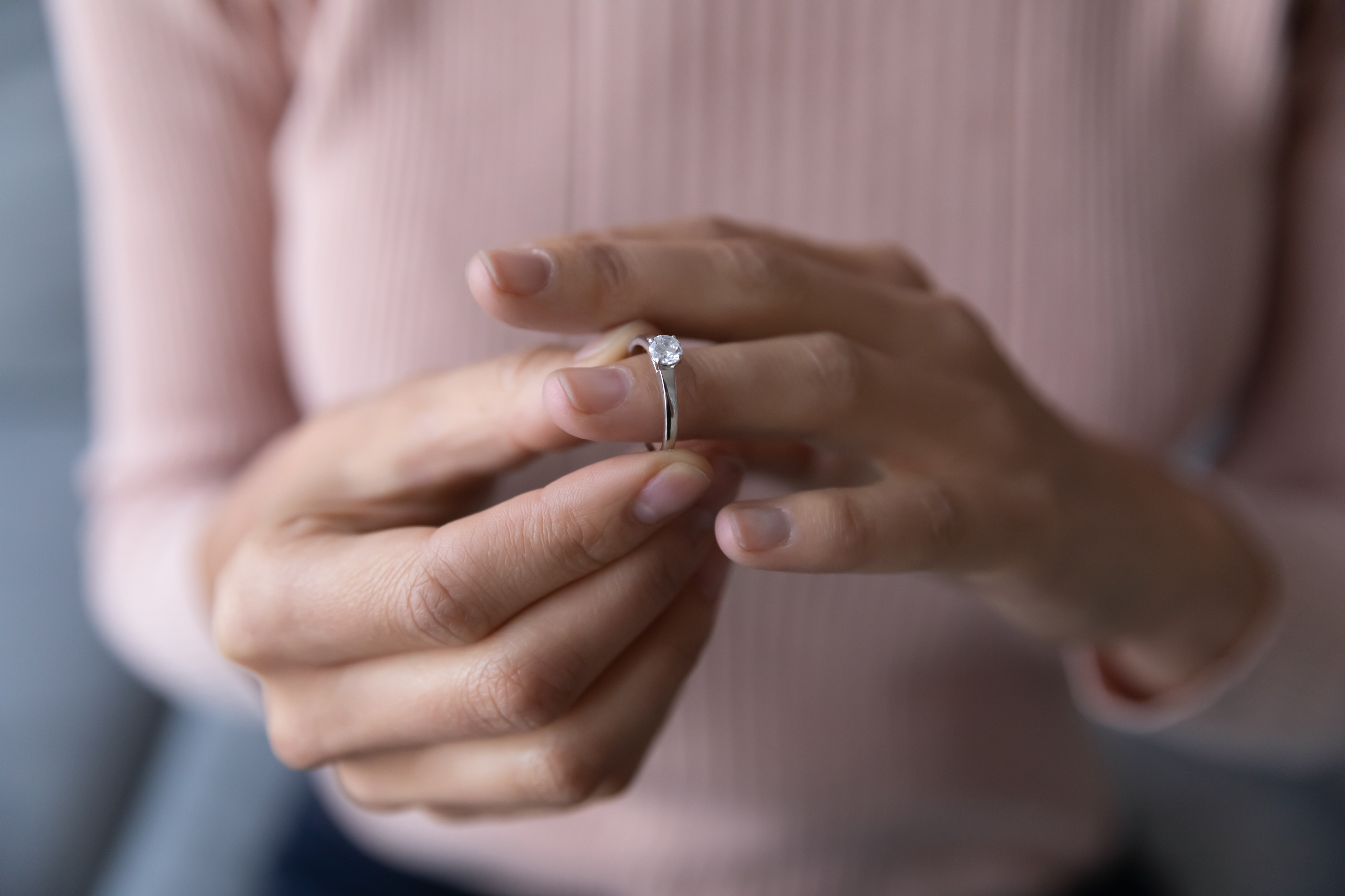 Frau nimmt einen Diamantring ab. | Quelle: Shutterstock