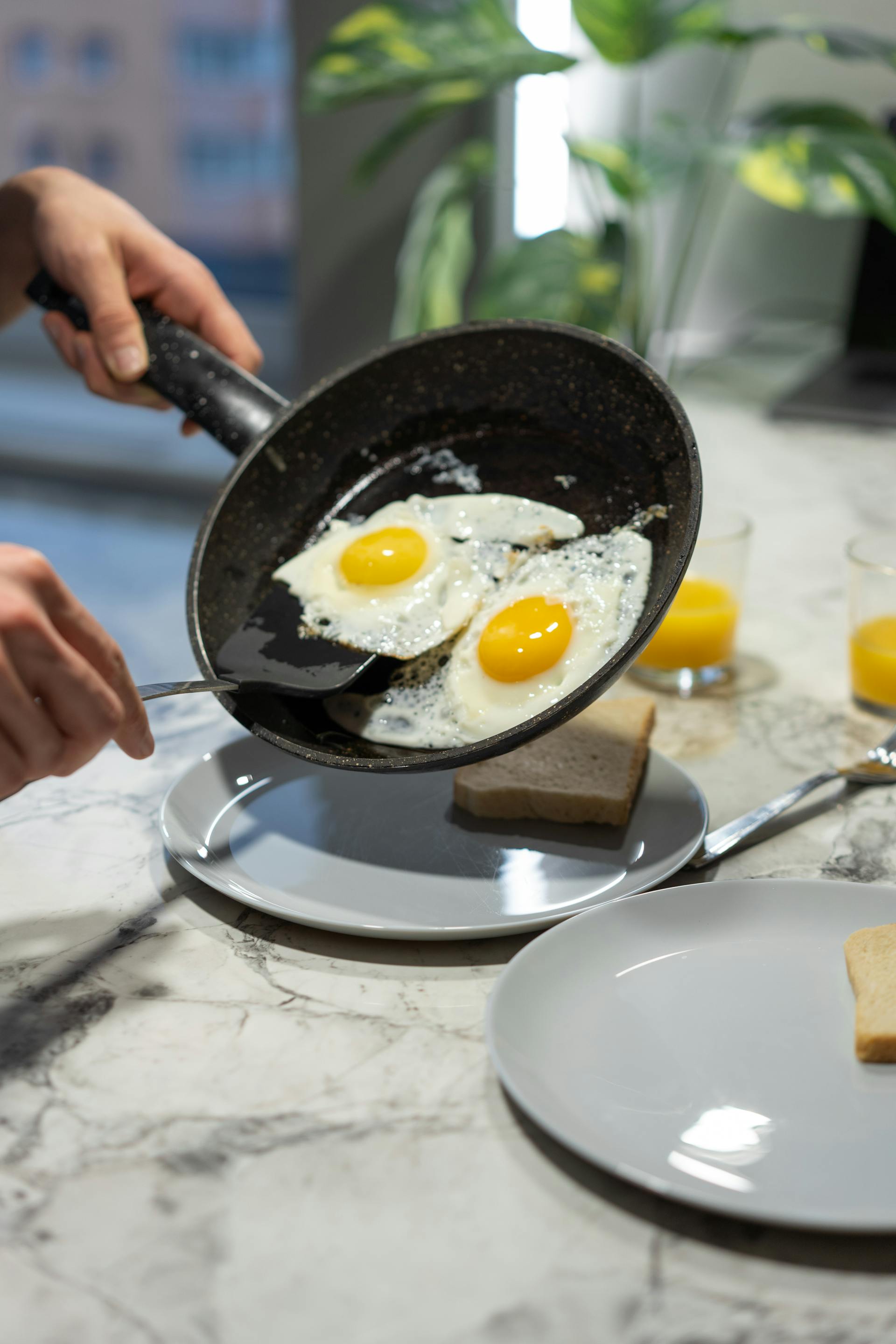 Eine Person hält eine Bratpfanne mit gekochten Eiern | Quelle: Pexels