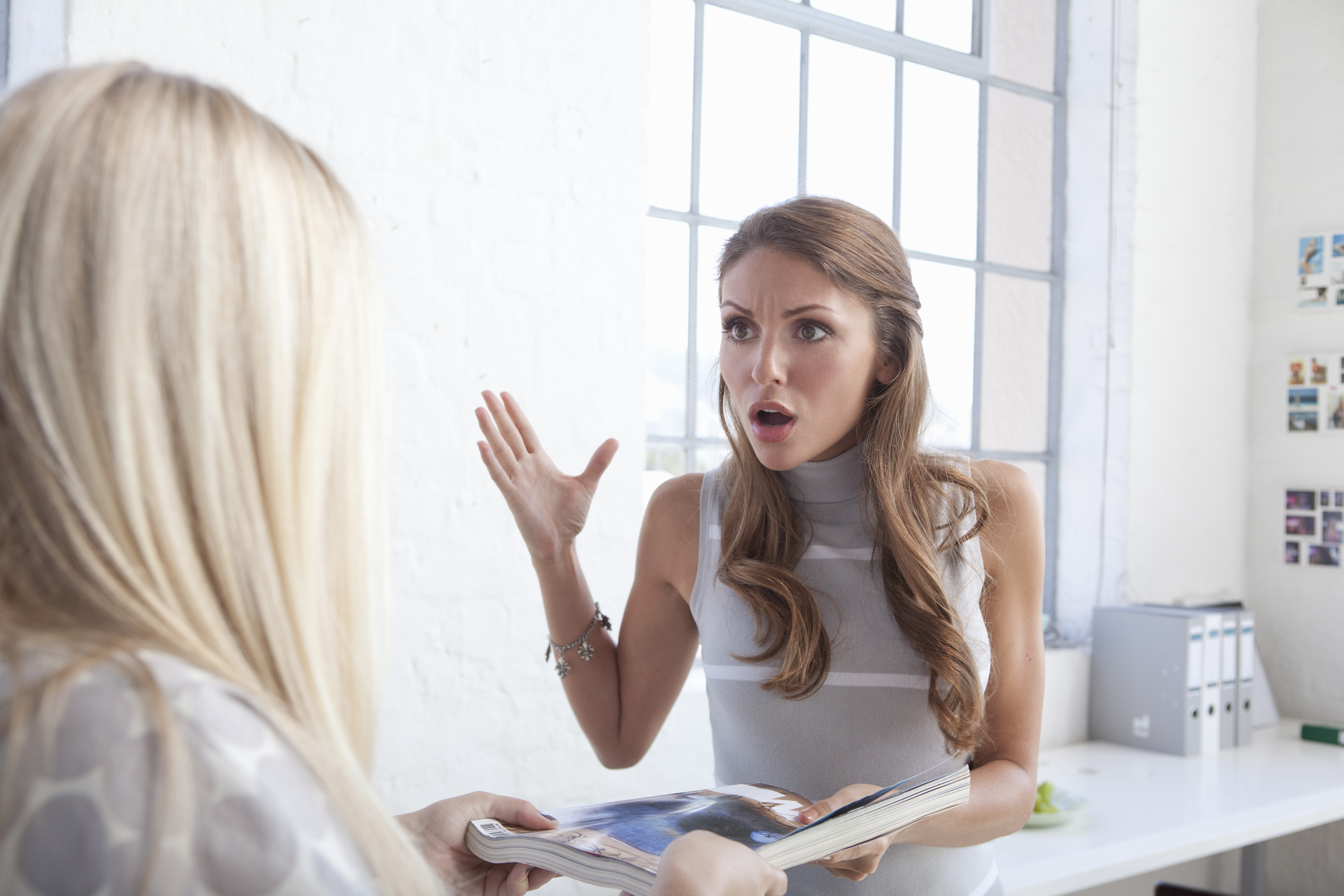 Eine Frau ist geschockt, während sie mit einer anderen Frau spricht | Getty Images