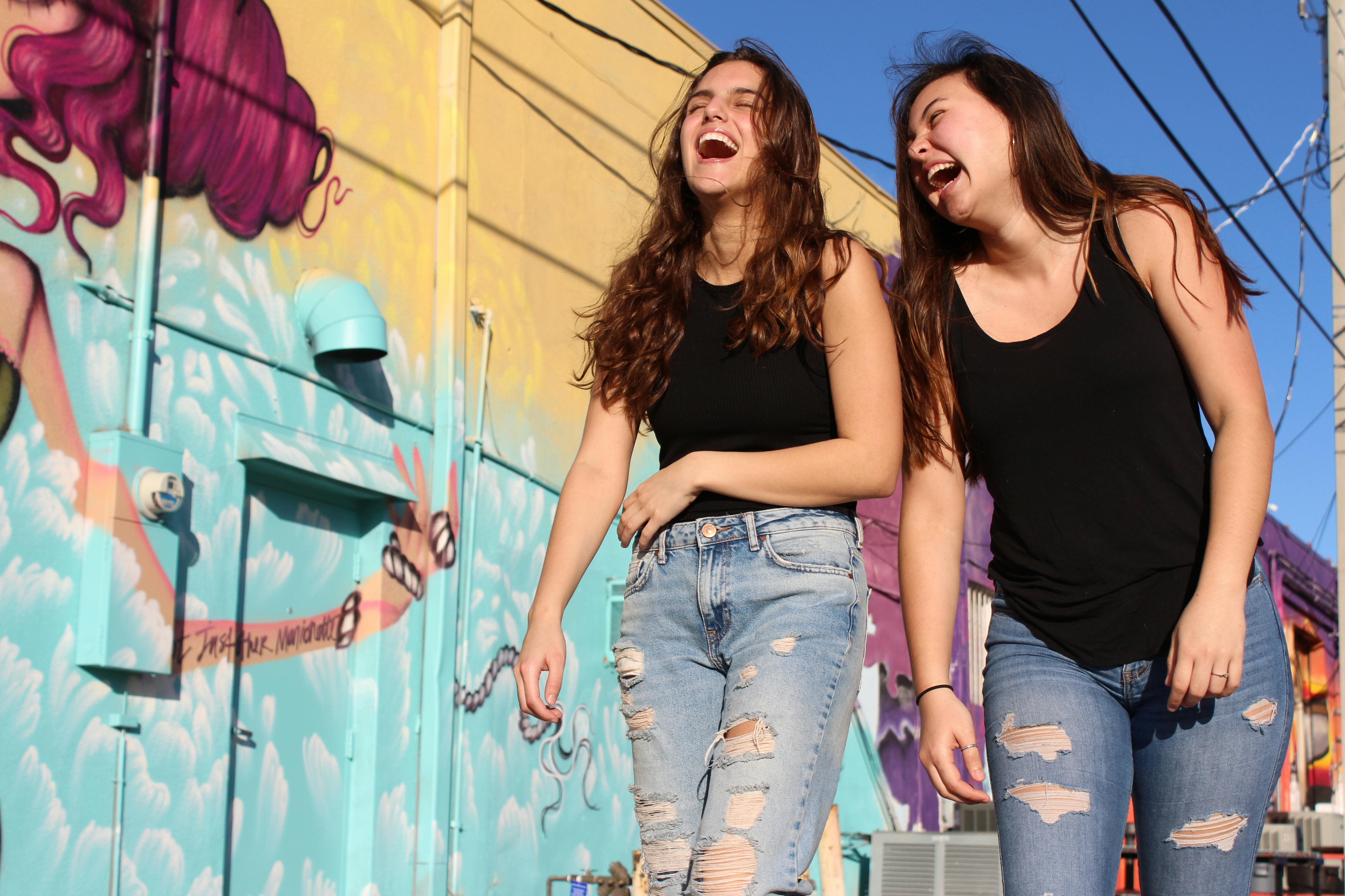 Zwei junge Frauen, die lachend spazieren gehen | Quelle: Savannah Dematteo auf Pexels