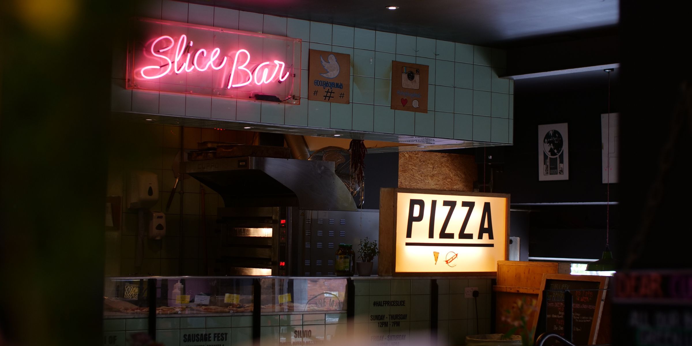 Innenraum einer Pizzeria mit Leuchtreklame und Thekendienst | Quelle: Shutterstock