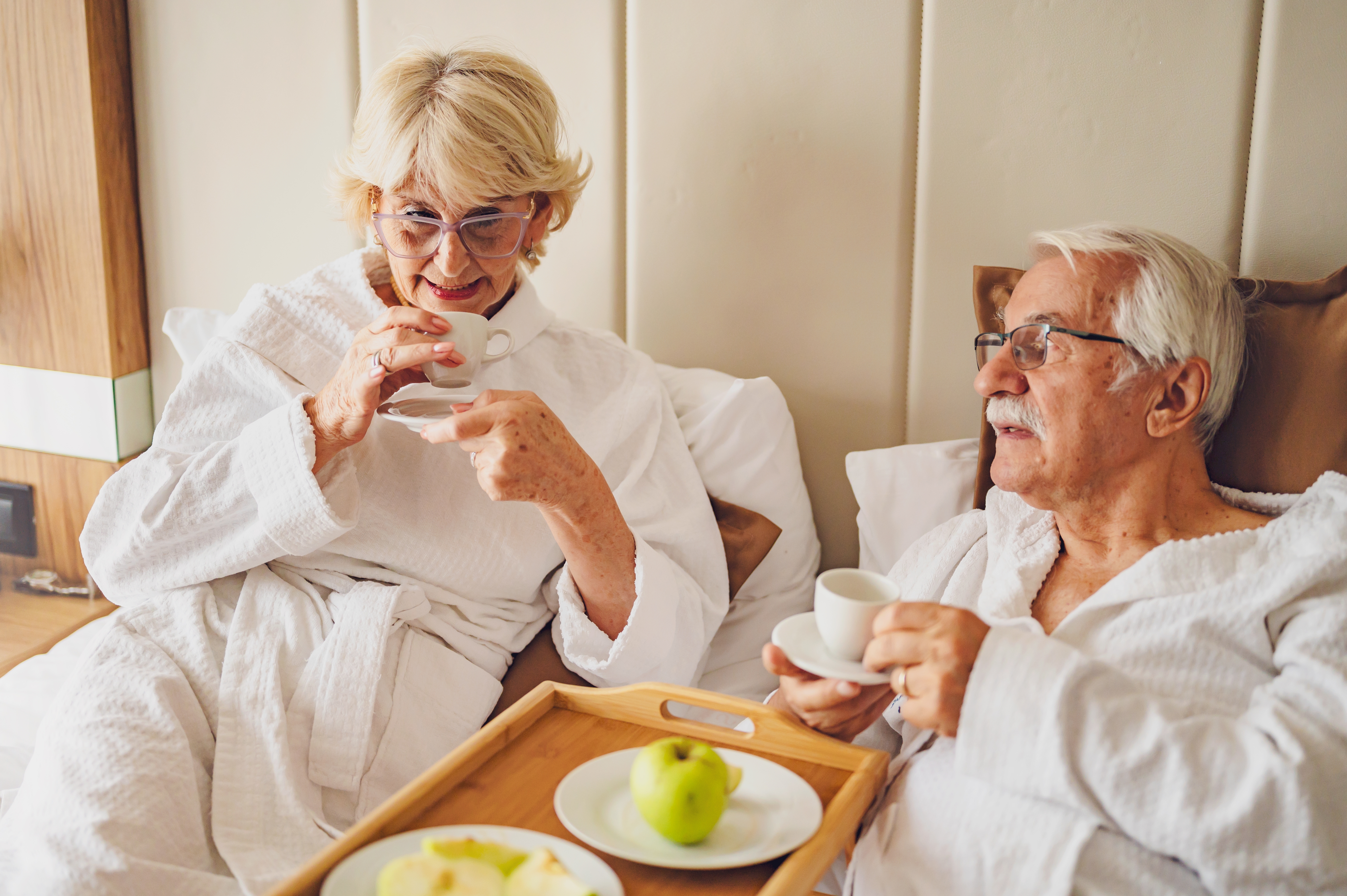 Ein älterer Mann und eine Frau in einem Hotelzimmer | Quelle: Shutterstock