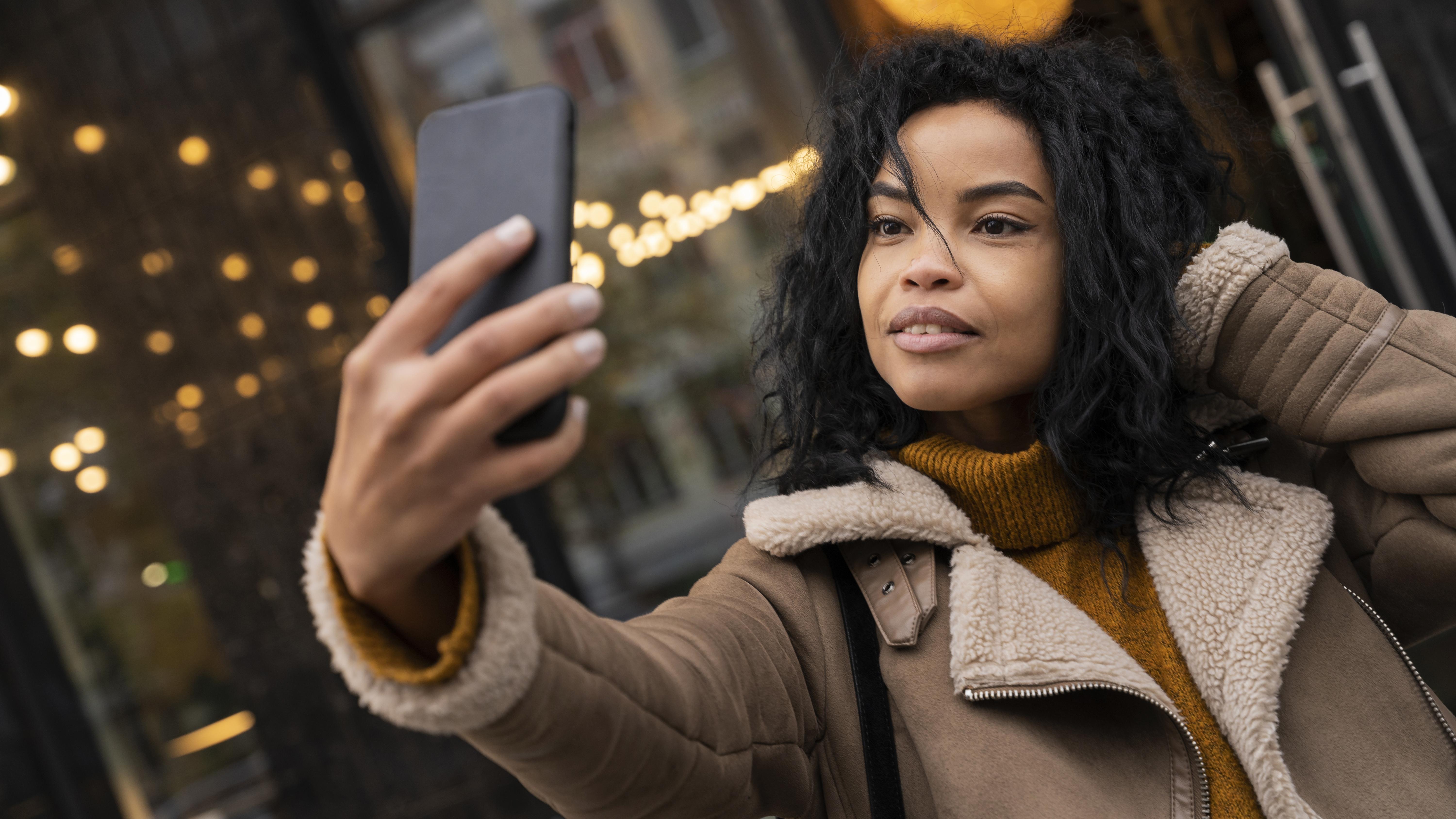 Eine Frau macht ein Selfie mit ihrem Telefon | Quelle: Freepik