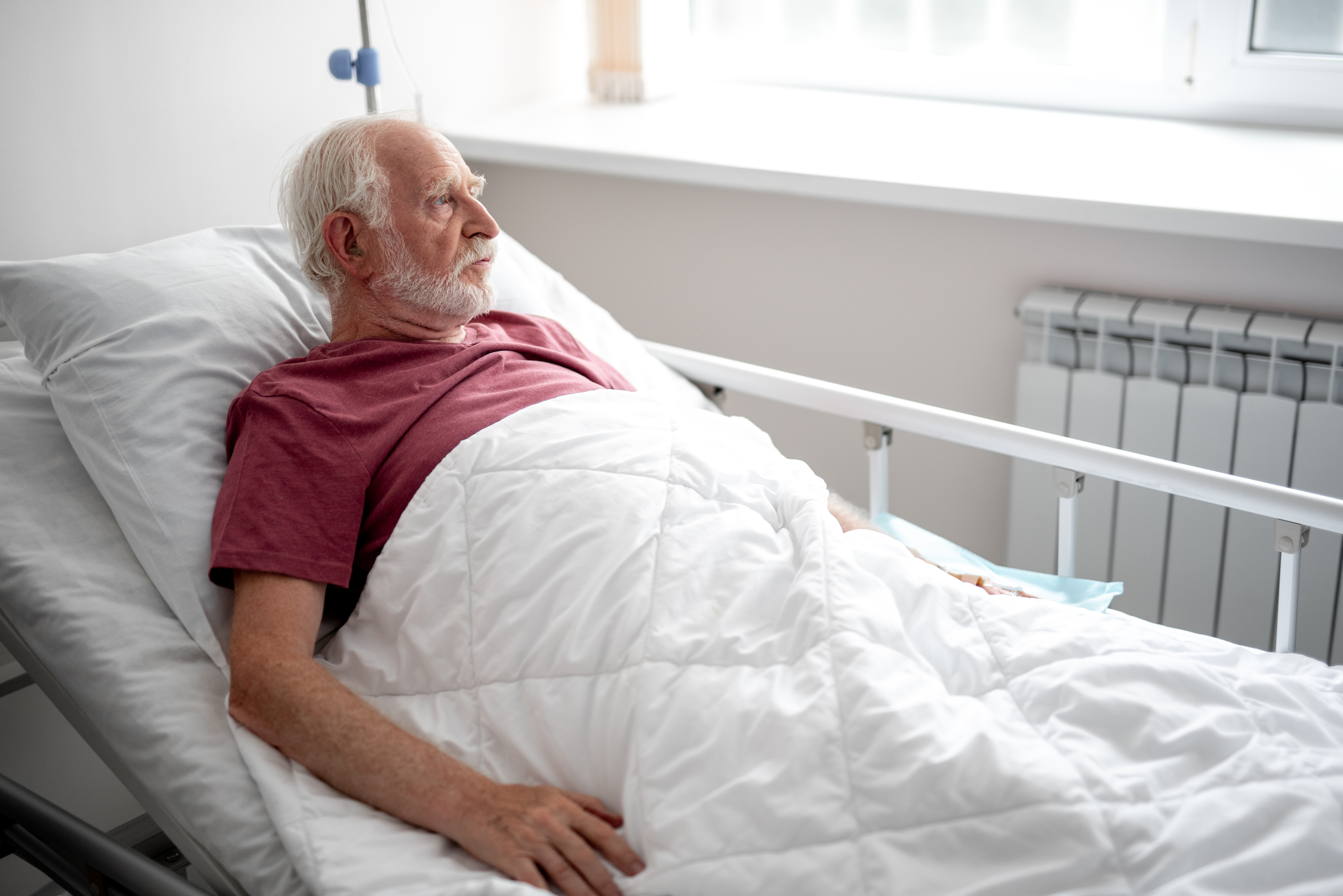 Ein älterer Mann liegt in einem Krankenhausbett | Quelle: Getty Images
