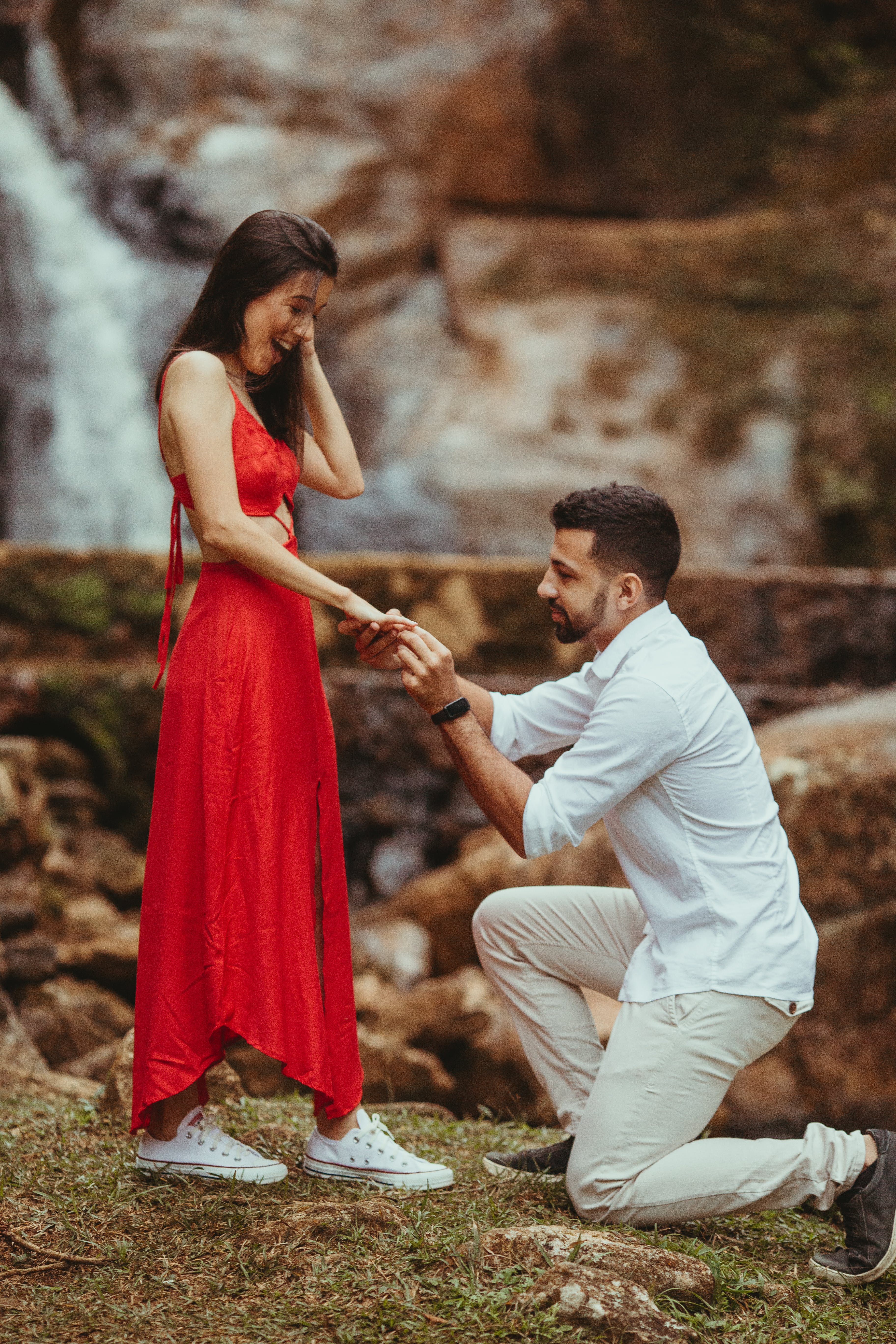 Ein Mann kniet auf einem Knie, während er seiner Partnerin im Freien einen Heiratsantrag macht | Quelle: Pexels
