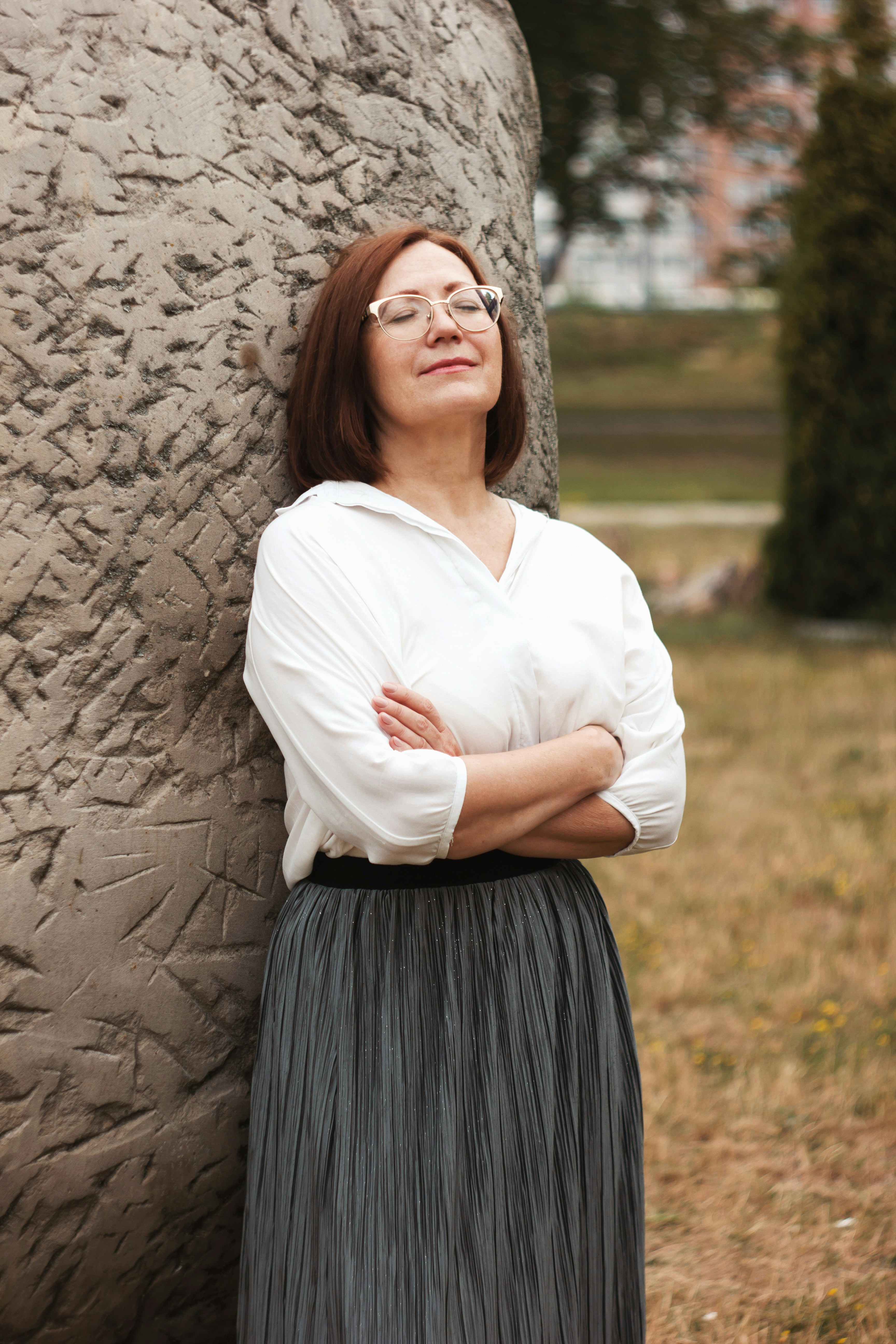 Eine Frau, die sich lächelnd an das Denkmal lehnt | Quelle: Unsplash