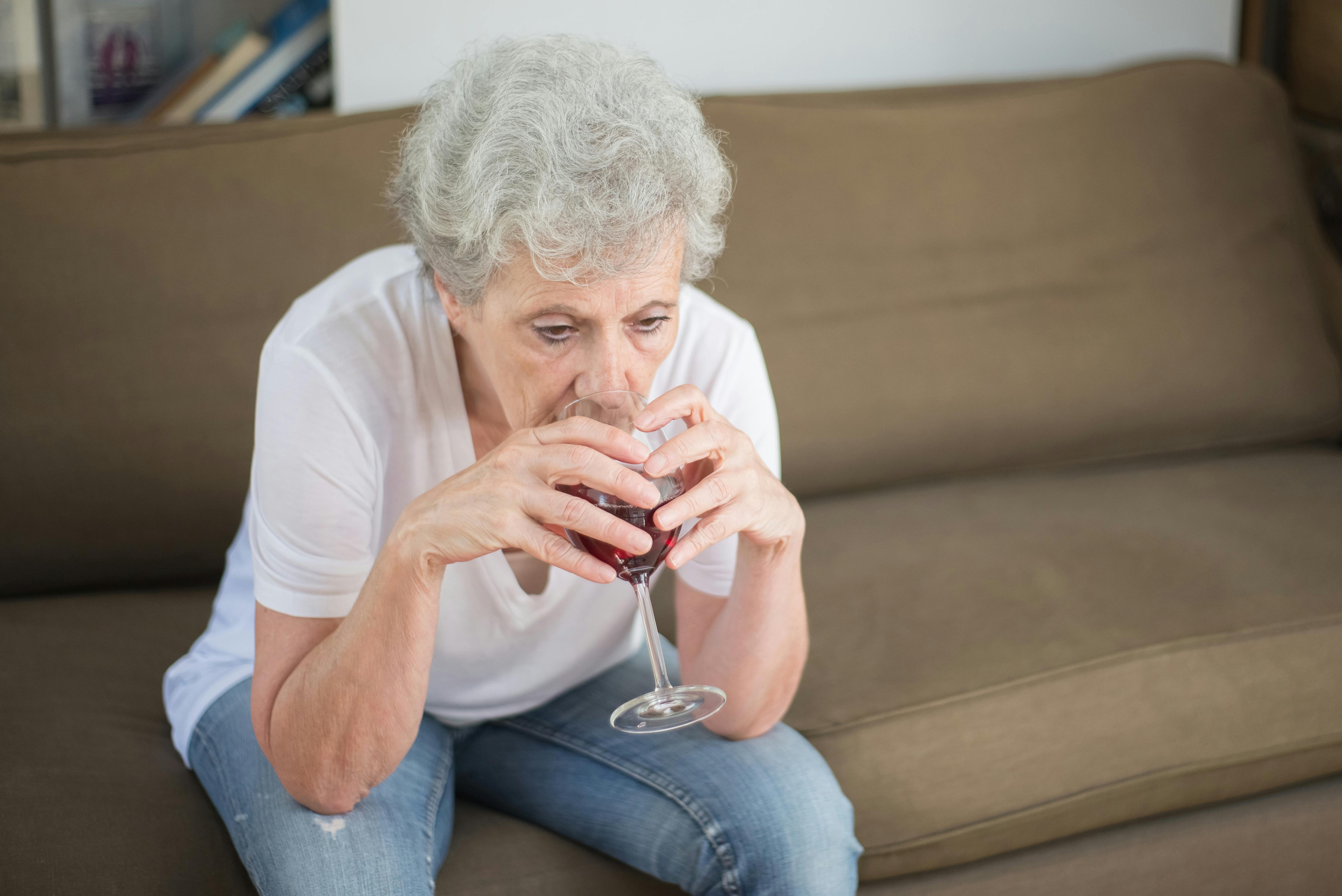 Eine traurige Frau, die alleine Wein trinkt | Quelle: Pexels