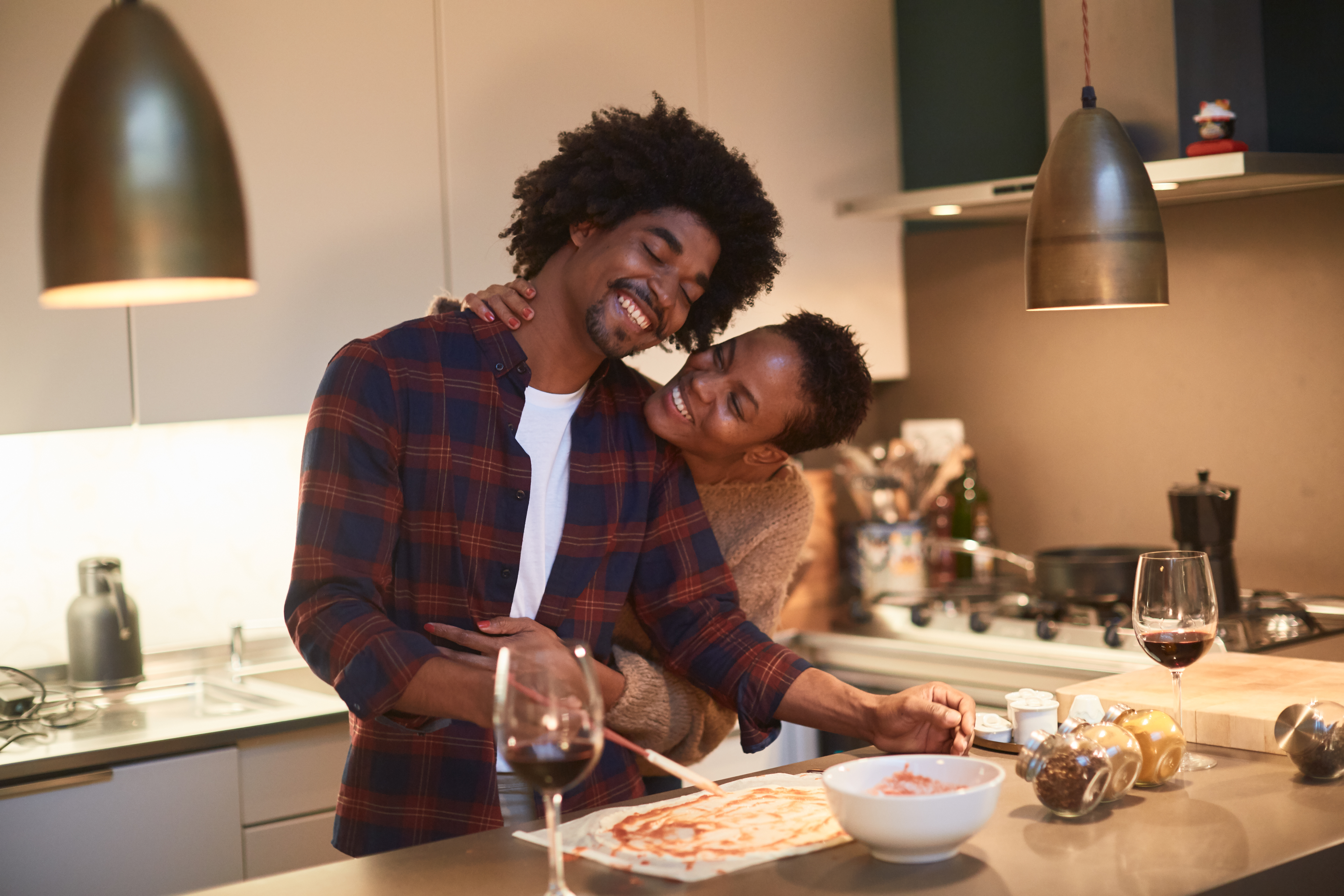 Junges Paar, das zu Hause kocht und den Heiligen Valentin feiert | Quelle: Getty Images