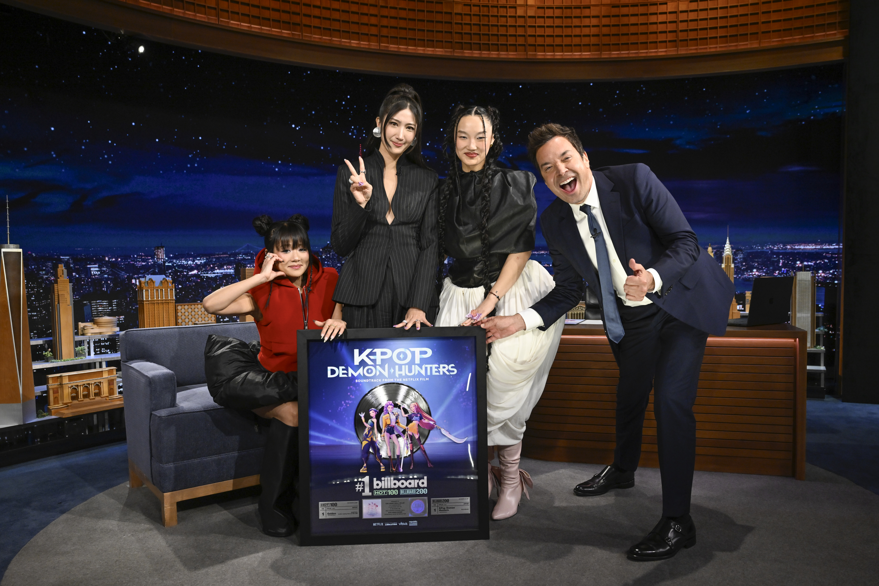 Rei Ami, Ejae und Audrey Nuna von „K-Pop Demon Hunters“ posieren mit dem Moderator Jimmy Fallon und ihrer Platin-Schallplatte am Dienstag, den 7. Oktober 2025. | Quelle: Getty Images