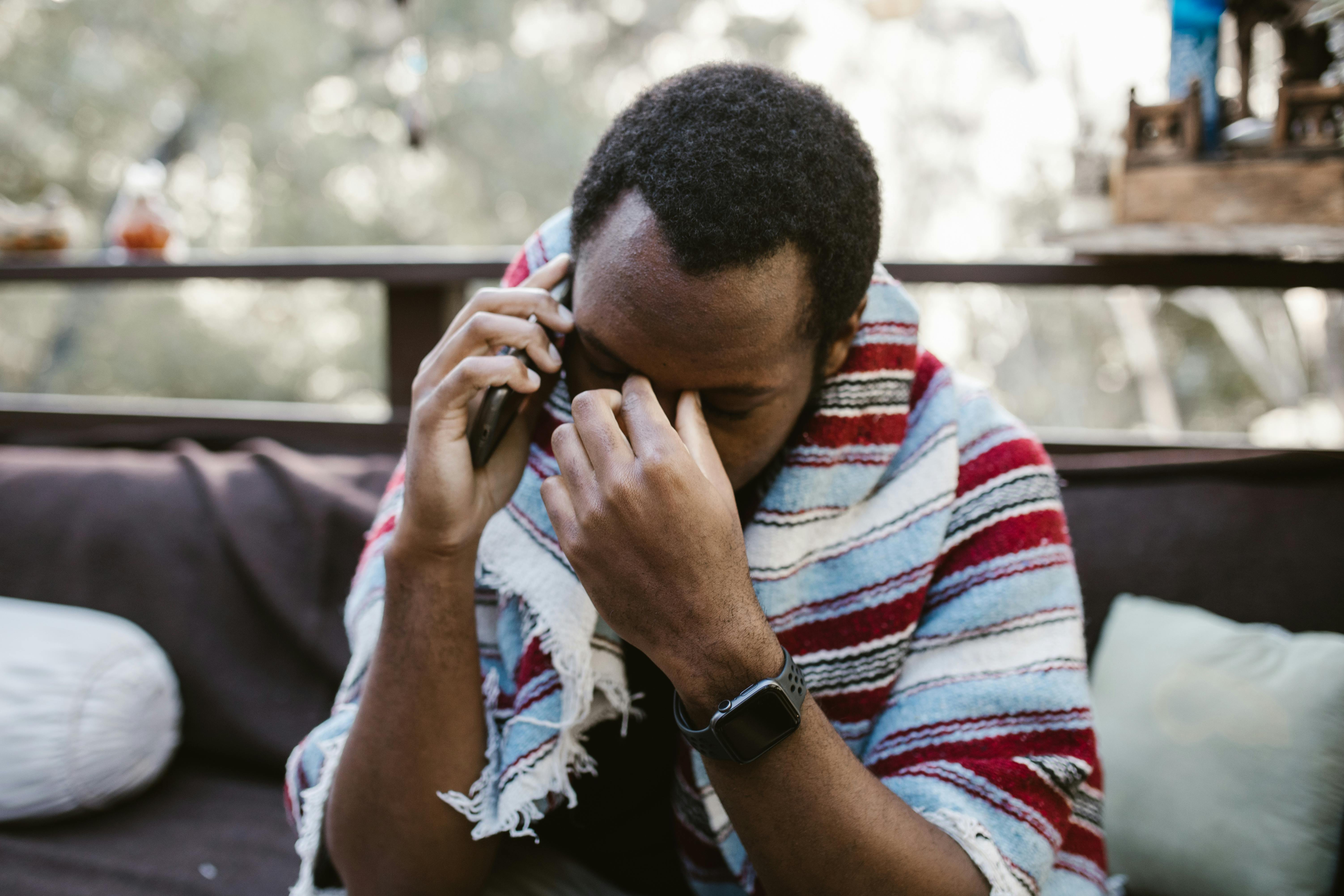 Ein frustrierter Mann mit seiner Hand an der oberen Schläfe, während er telefoniert | Quelle: Pexels