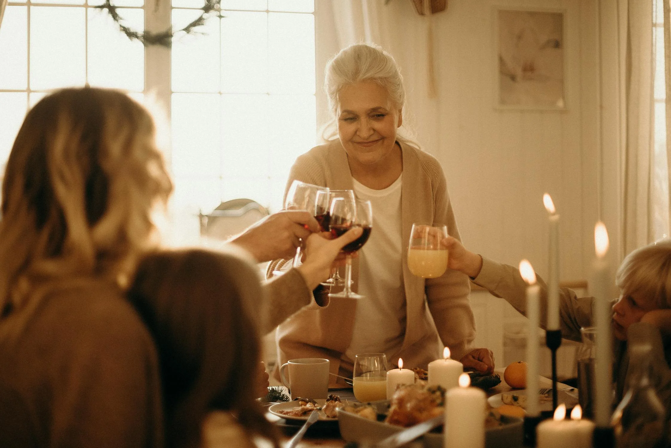 Eine Frau stößt bei einem Abendessen an | Quelle: Pexels