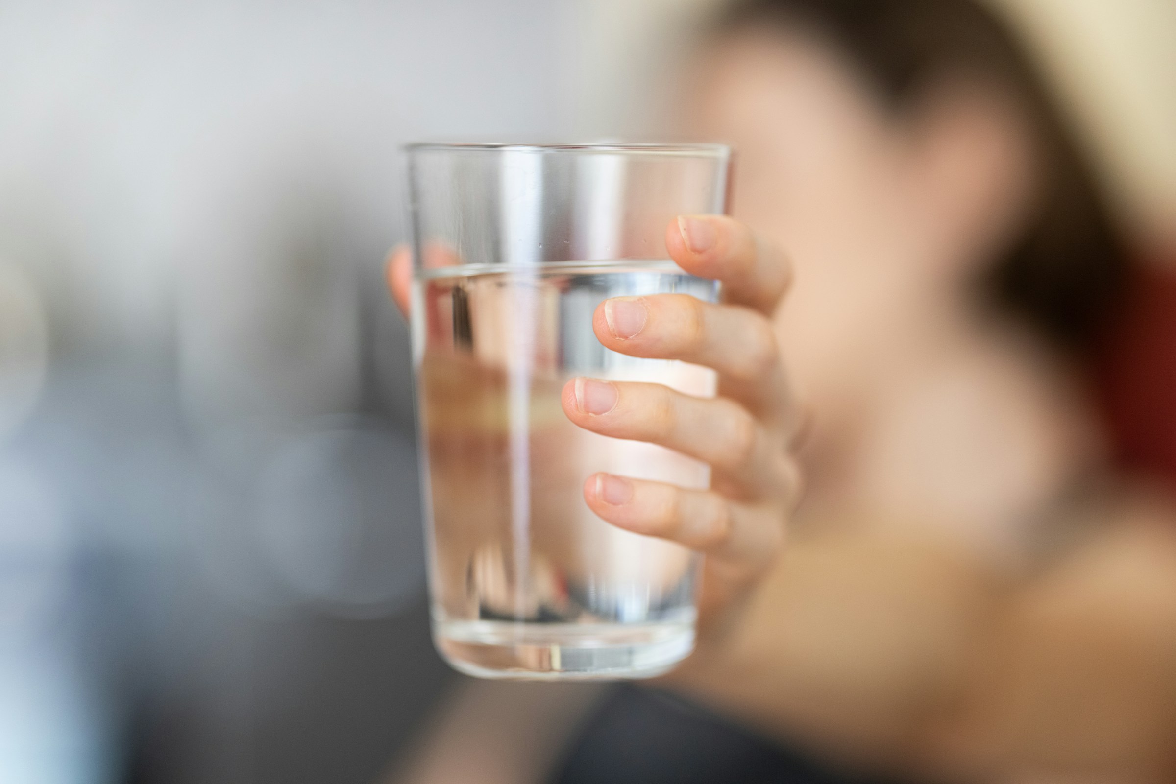 Eine Person hält ein Glas Wasser in der Hand | Quelle: Unsplash