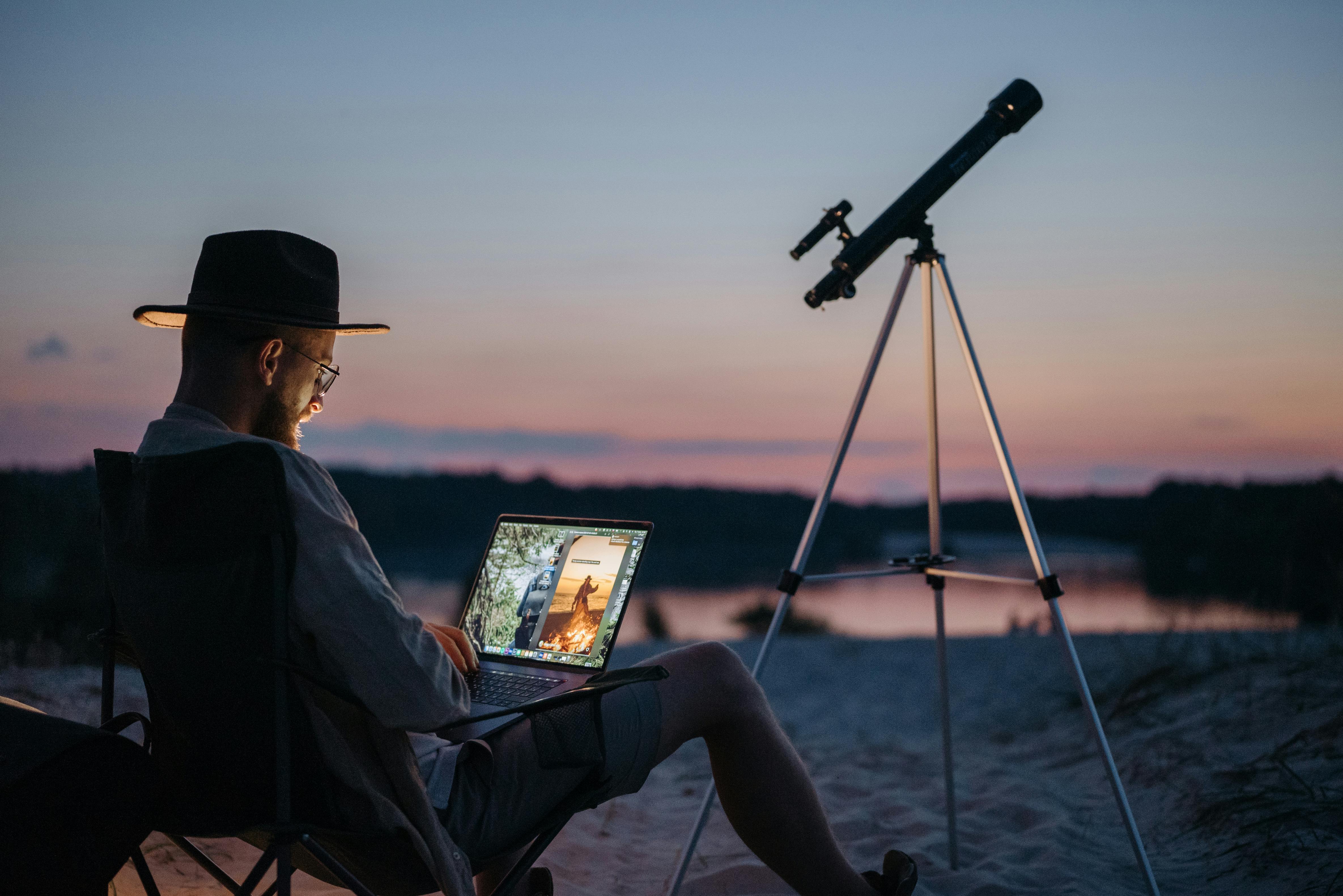 Ein Mann im Freien mit einem in der Nähe aufgestellten Teleskop | Quelle: Pexels