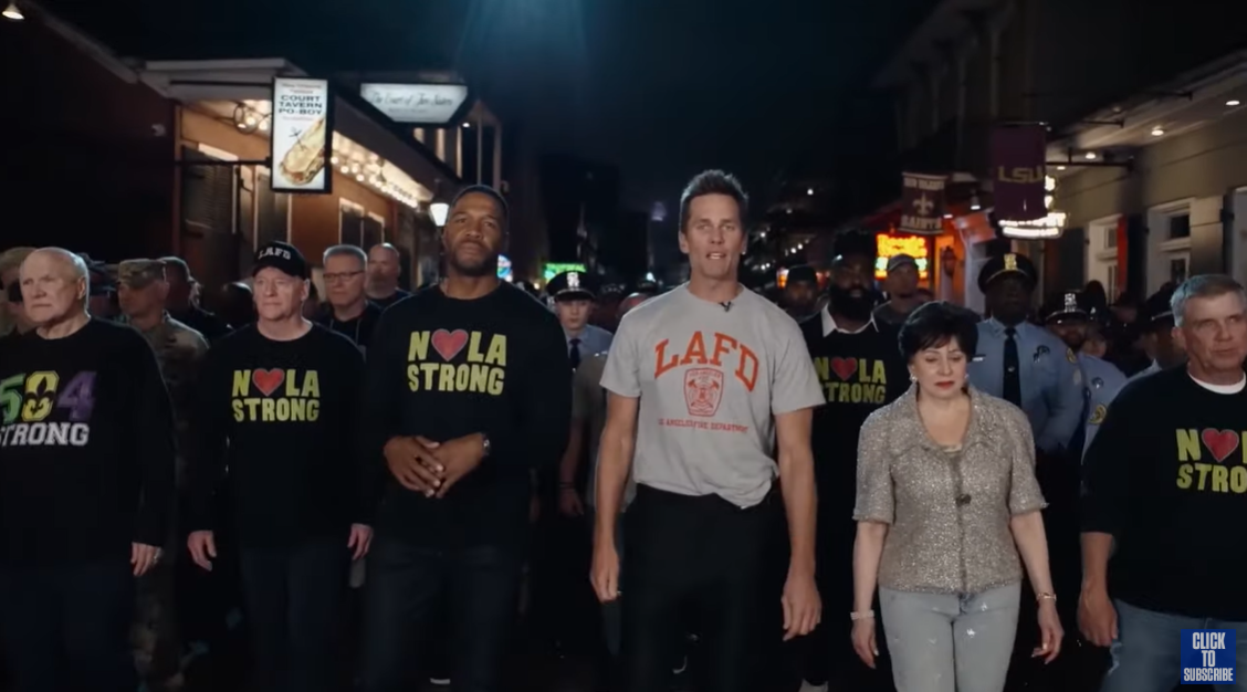 Michael Strahan und Tom Brady spazieren mit einer Gruppe von Rettungskräften auf der Bourbon Street in New Orleans | Quelle: YouTube/NFL