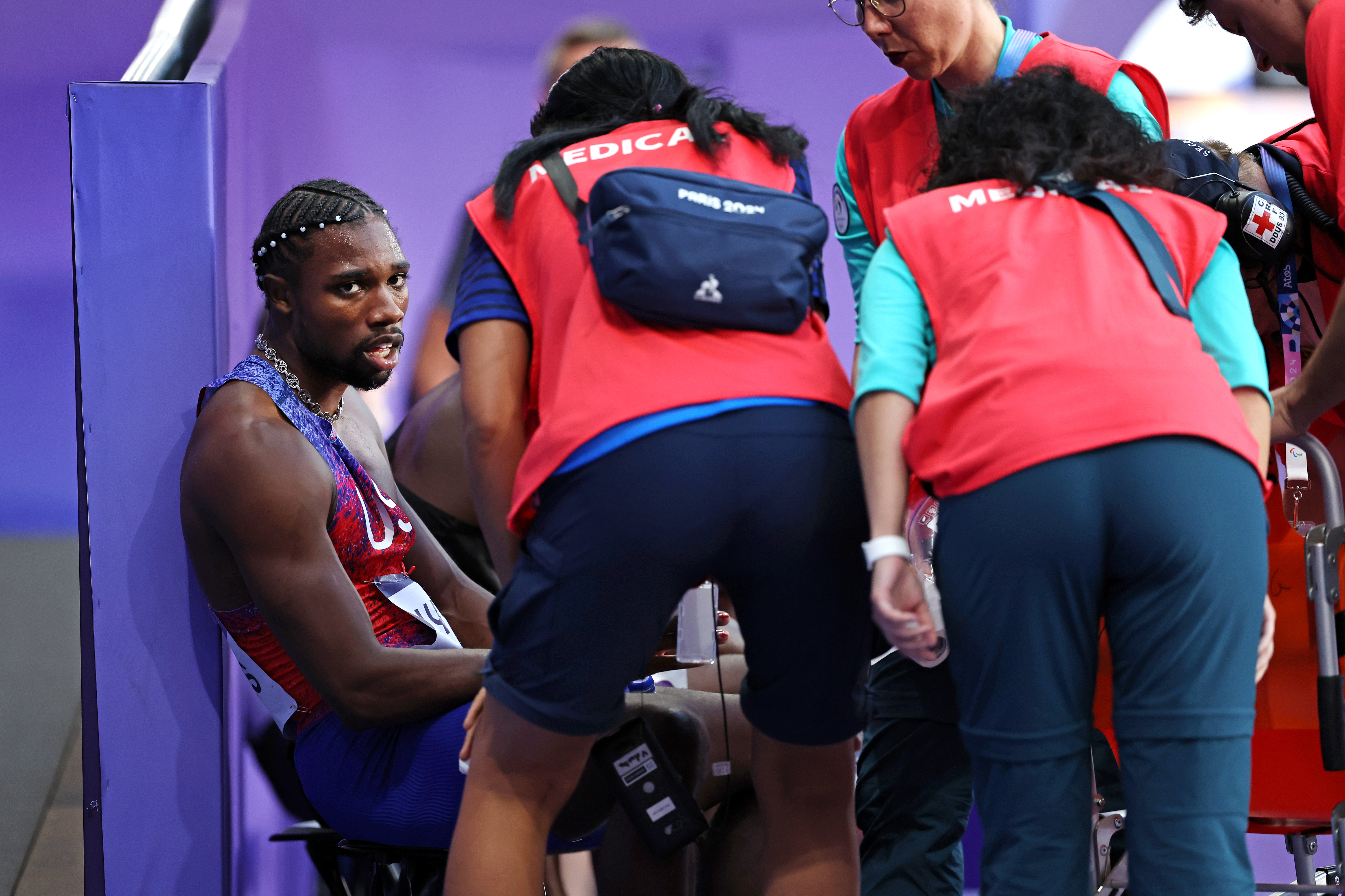 Noah Lyles vom Team U.S. mit dem medizinischen Personal nach dem 200m-Finale der Männer bei den Olympischen Spielen in Paris am 8. August 2024 | Quelle: Getty Images