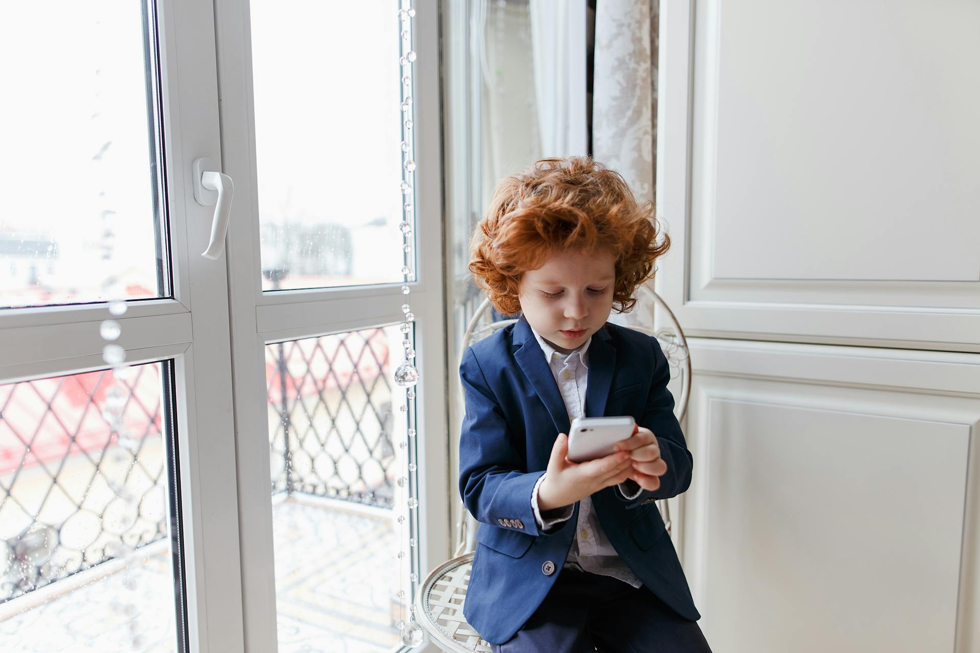 Ein kleiner Junge schaut auf ein Smartphone | Quelle: Pexels