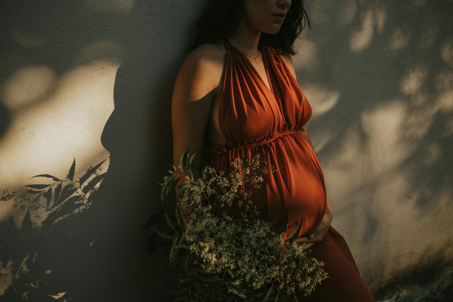 Eine schwangere Frau, die an einer Wand steht | Quelle: Pexels
