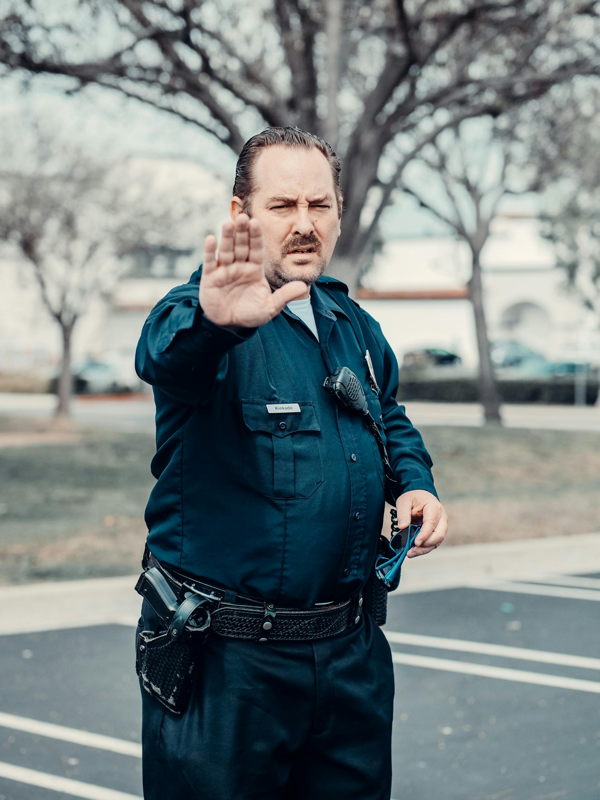 Ein Polizist mit erhobenem Arm | Quelle: Pexels