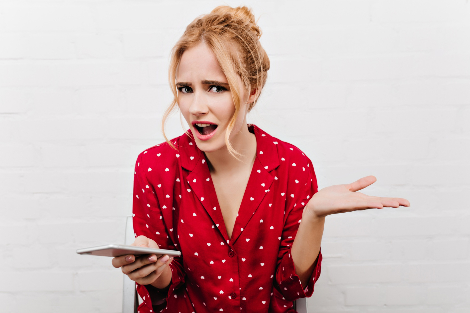 Eine verwirrte Frau hält ihr Telefon | Quelle: Freepik
