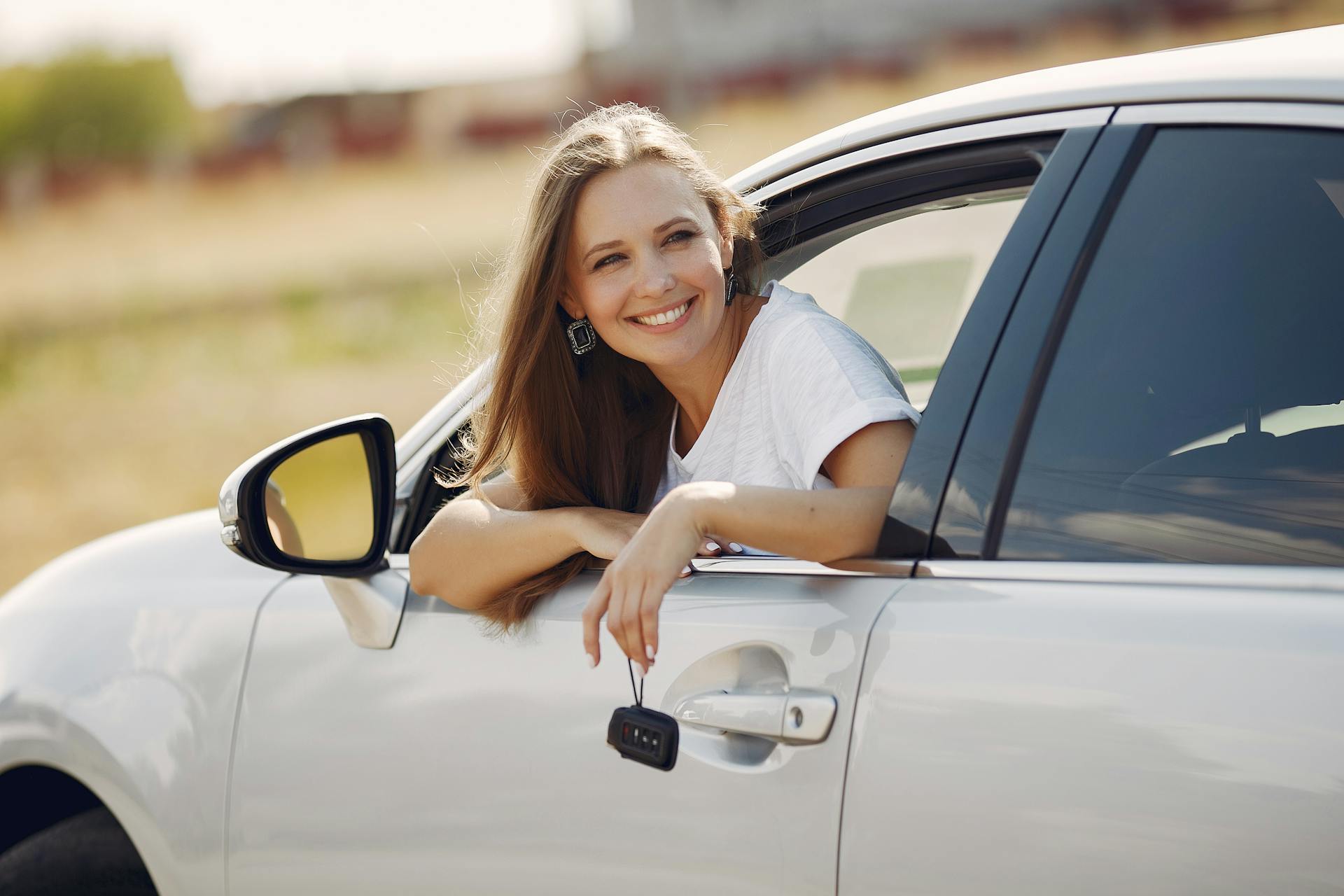 Eine Frau späht aus einem Autofenster, während sie die Schlüssel hält | Quelle: Pexels