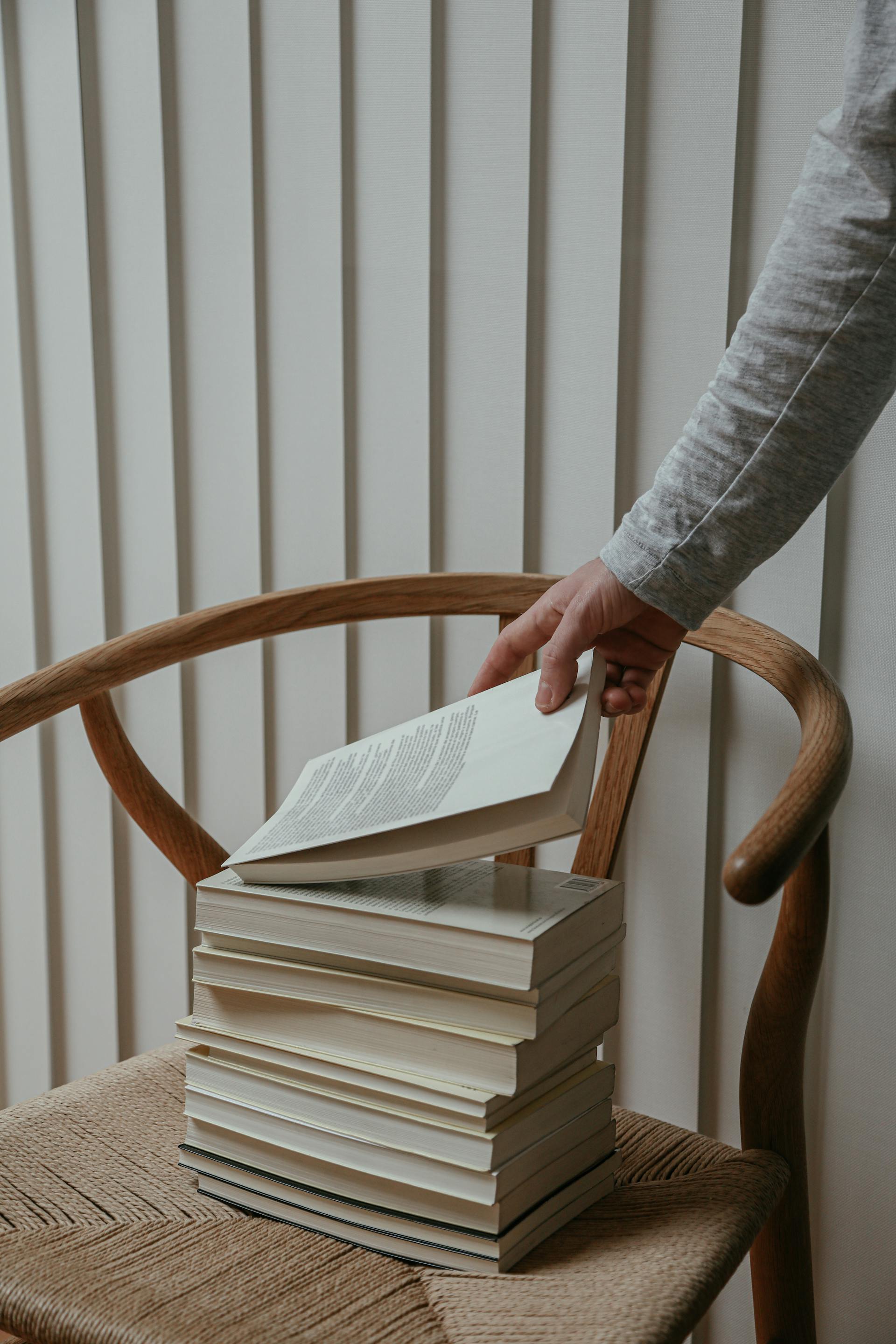 Eine Person, die nach einem Buch greift | Quelle: Pexels
