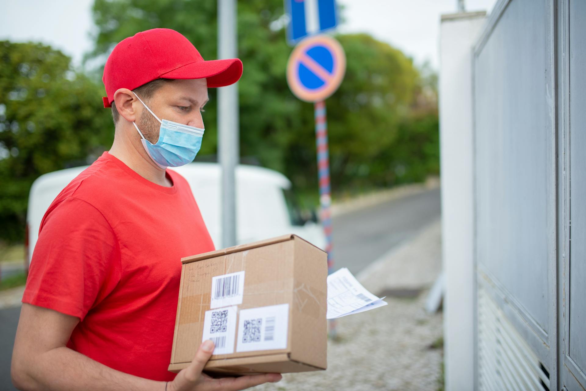 Ein Zusteller mit einem Paket | Quelle: Pexels