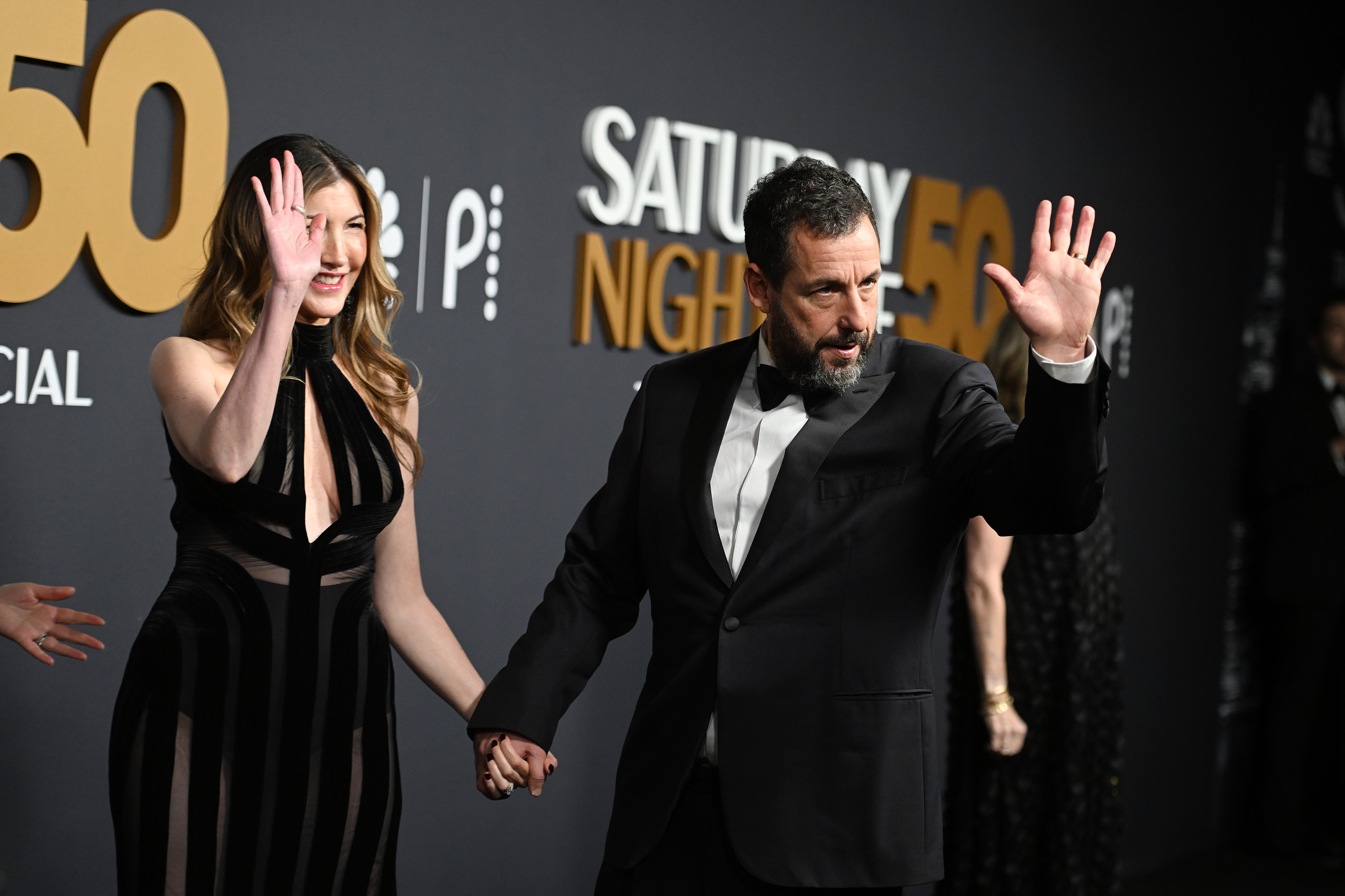 Jackie Sandler und Adam Sandler winken beim "SNL50: The Anniversary Special" auf dem 30 Rockefeller Plaza am 16. Februar 2025 in New York | Quelle: Getty Images