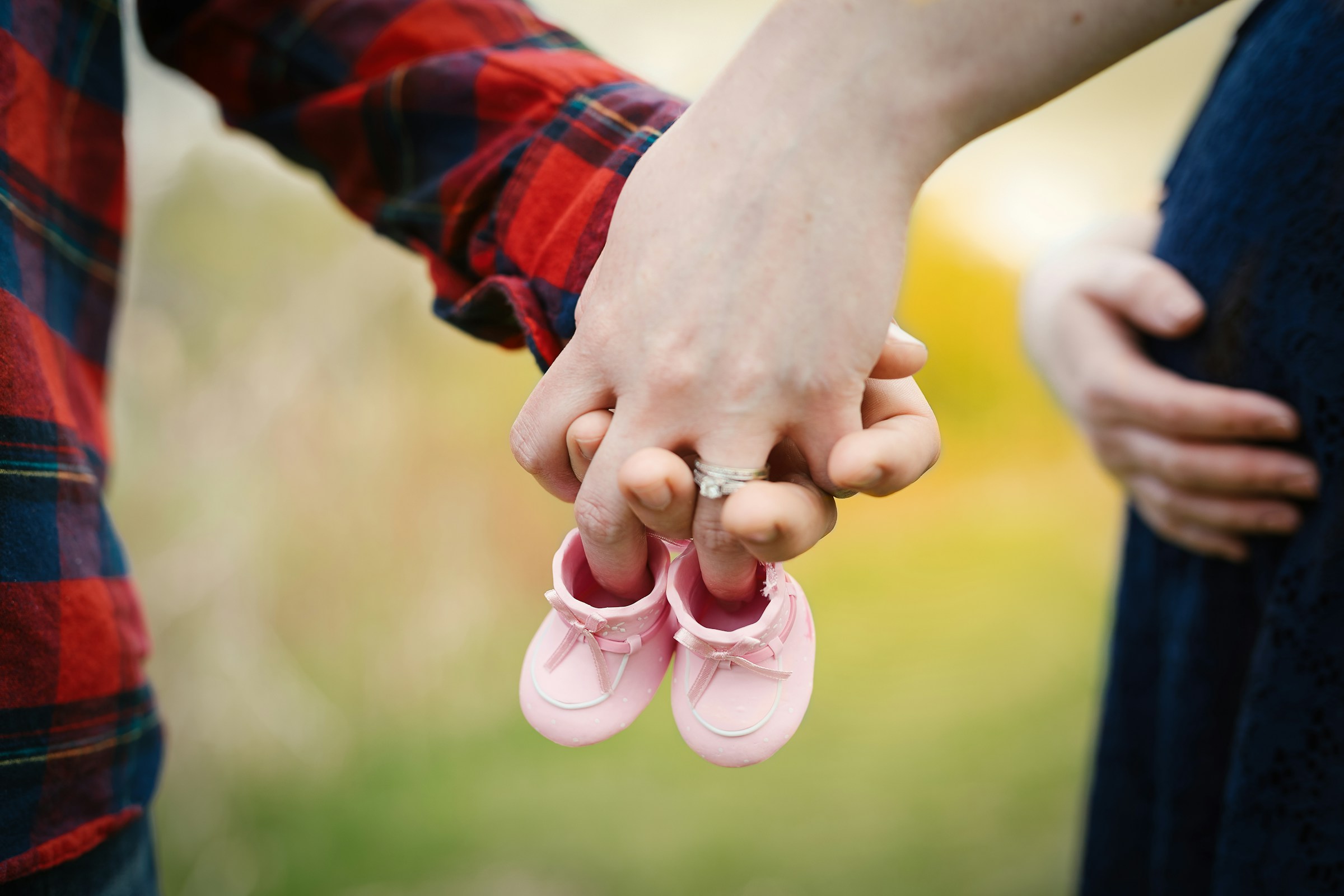 Ein werdendes Paar mit einem Paar winziger rosa Schuhe | Quelle: Unsplash