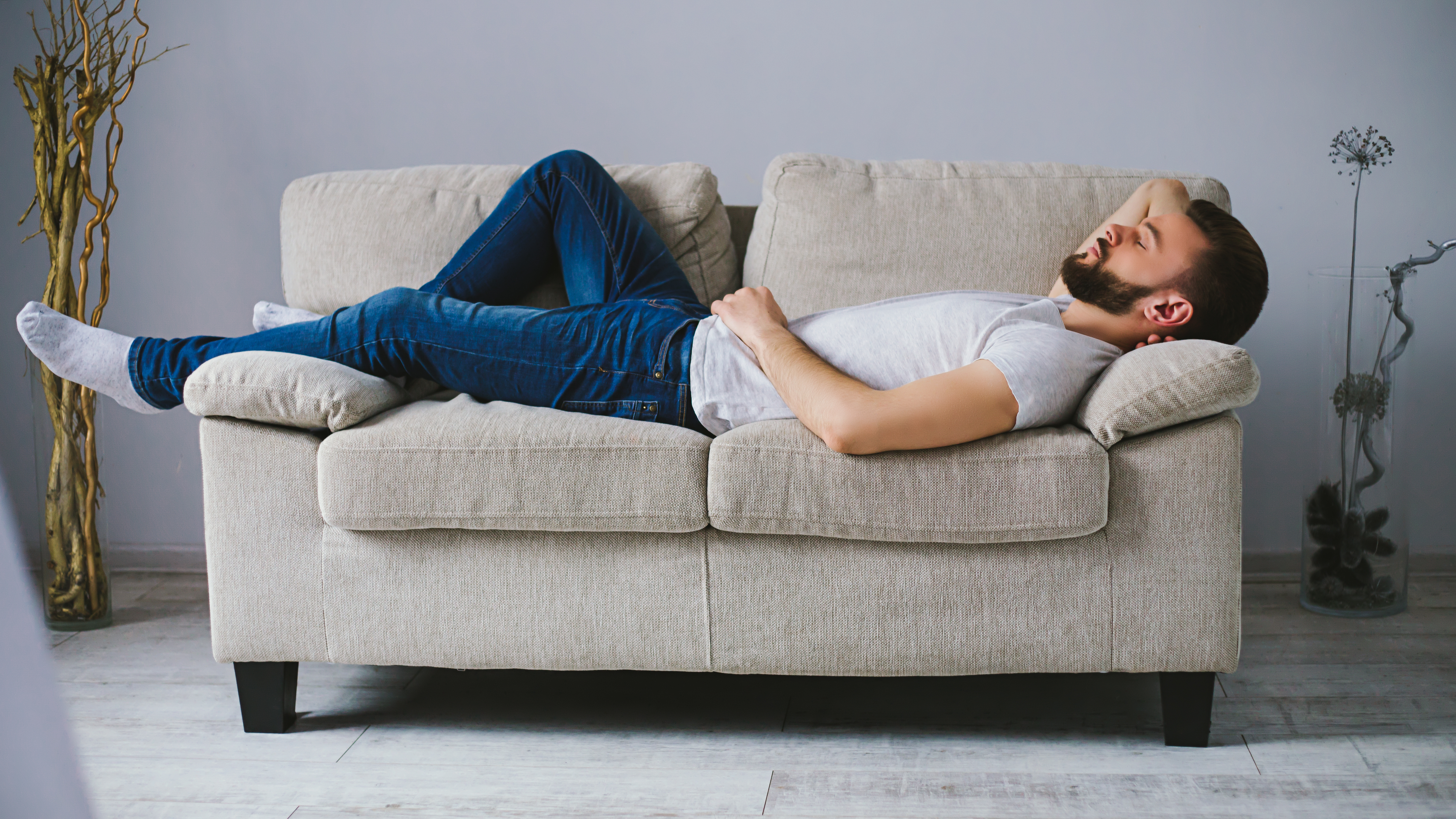 Ein Mann schläft auf einer Couch | Quelle: Shutterstock